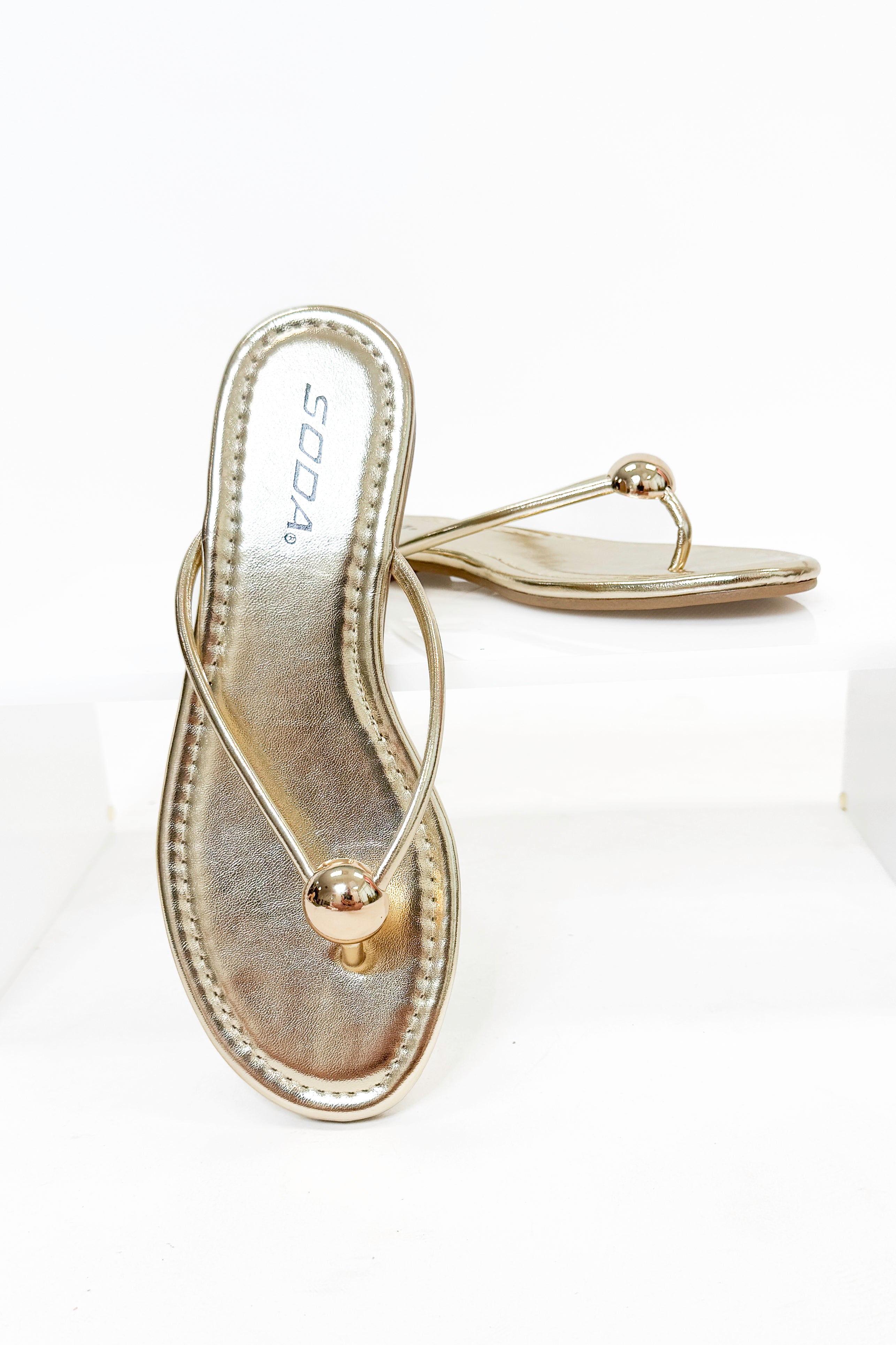 Elwood- Gold Ball Flip Flop against white studio background