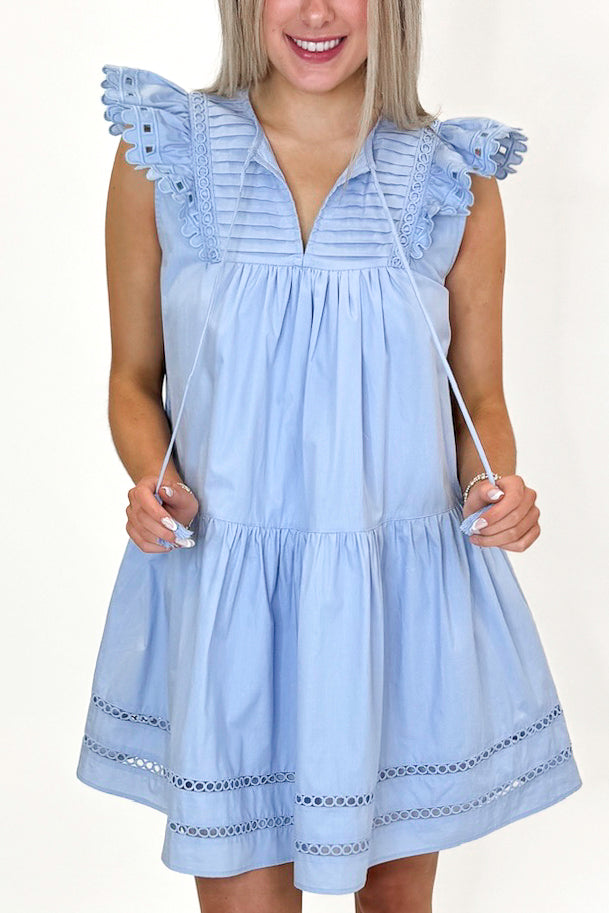 Front detail view of woman wearing Light Blue Eyelet Detail Dress with sandals against white studio background.