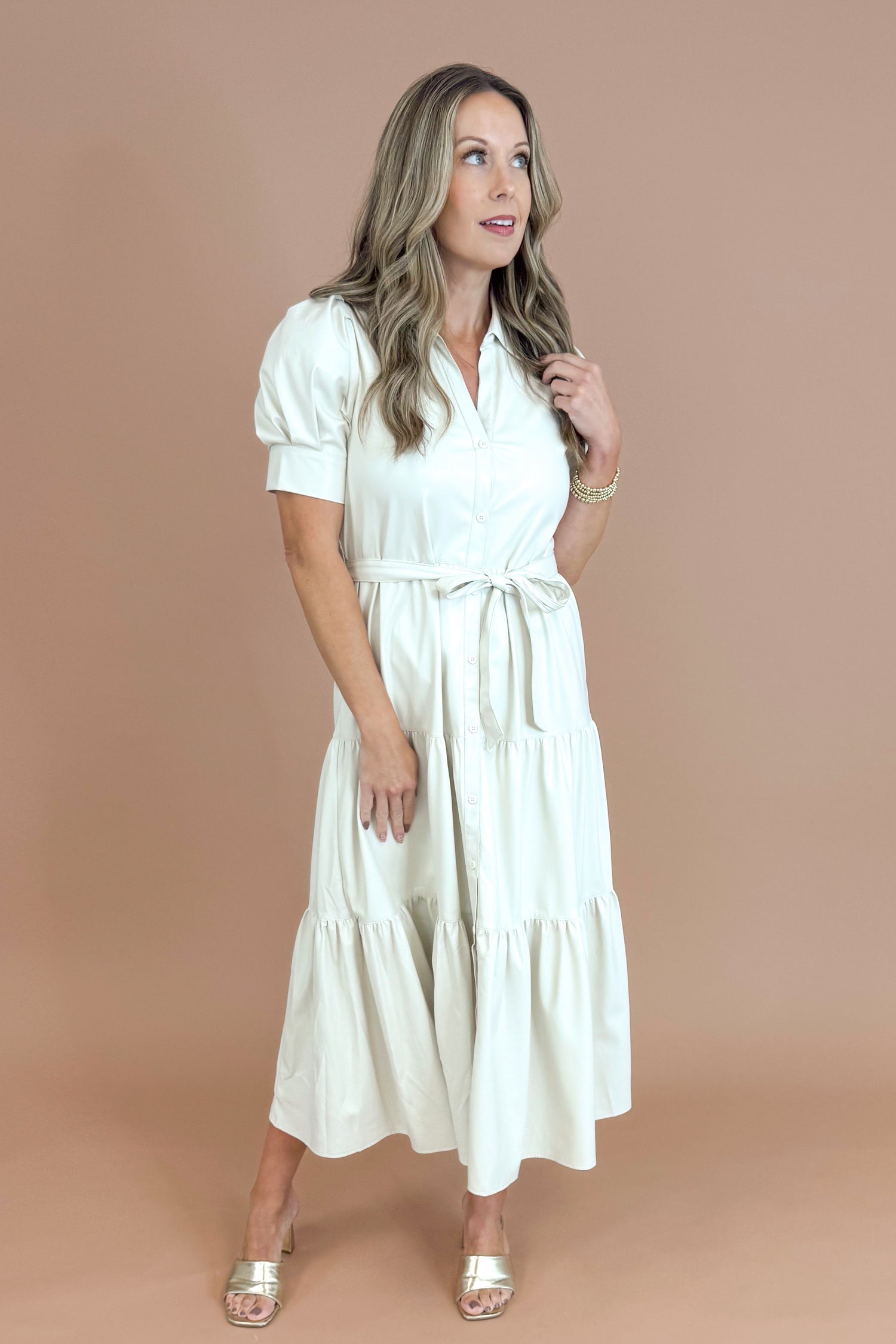 Woman wearing a white dress against a brown background