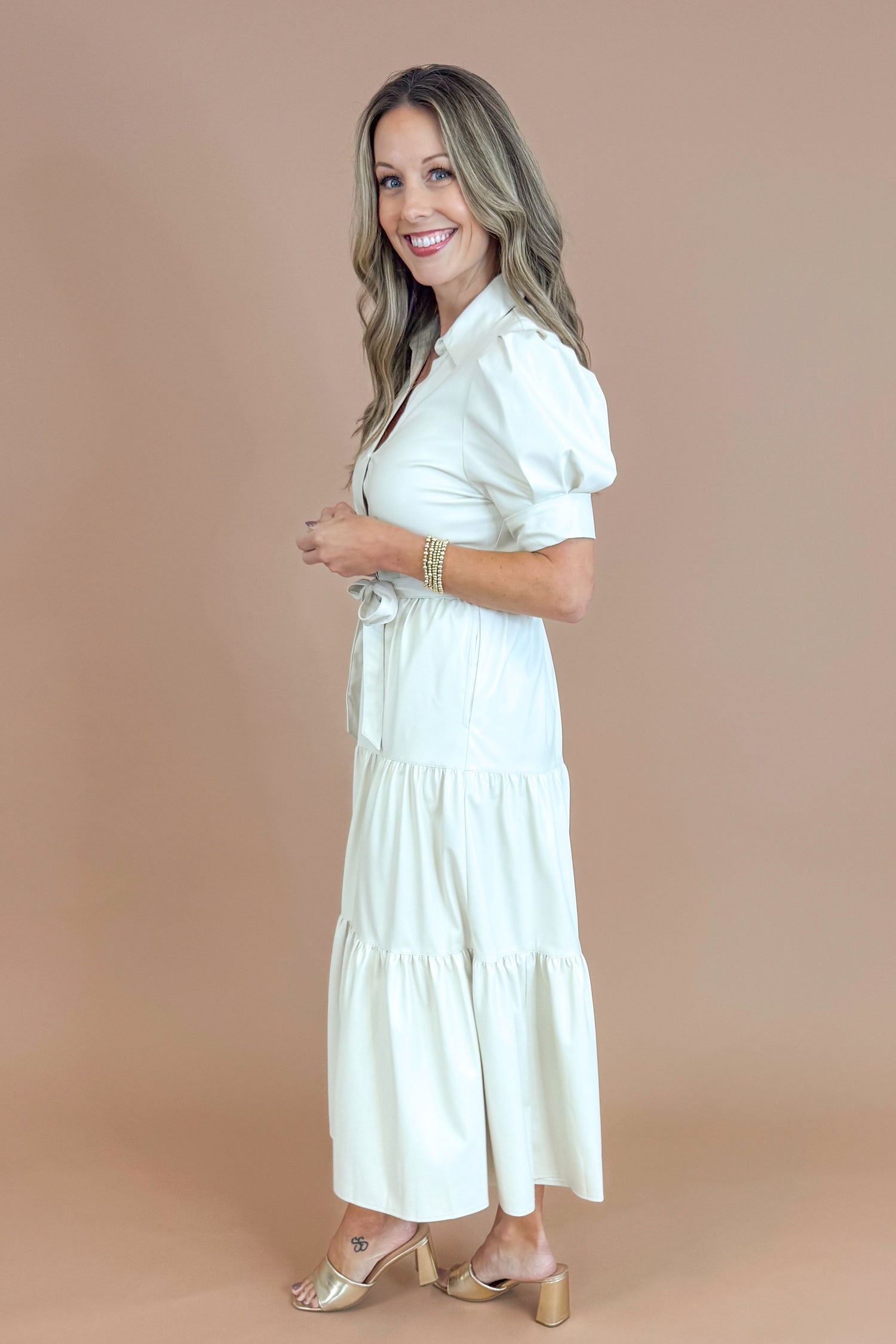 Woman wearing a white dress against a beige background