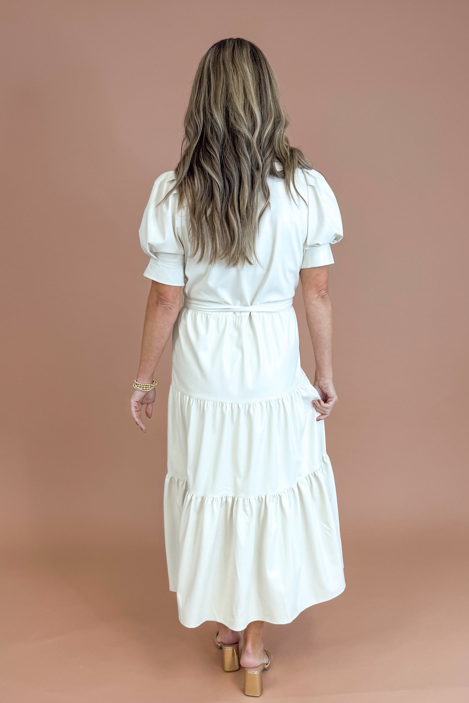 Woman wearing a white dress against a brown background
