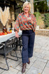 Woman outside with drink wearing Brown & Teal Printed Top and jeans.