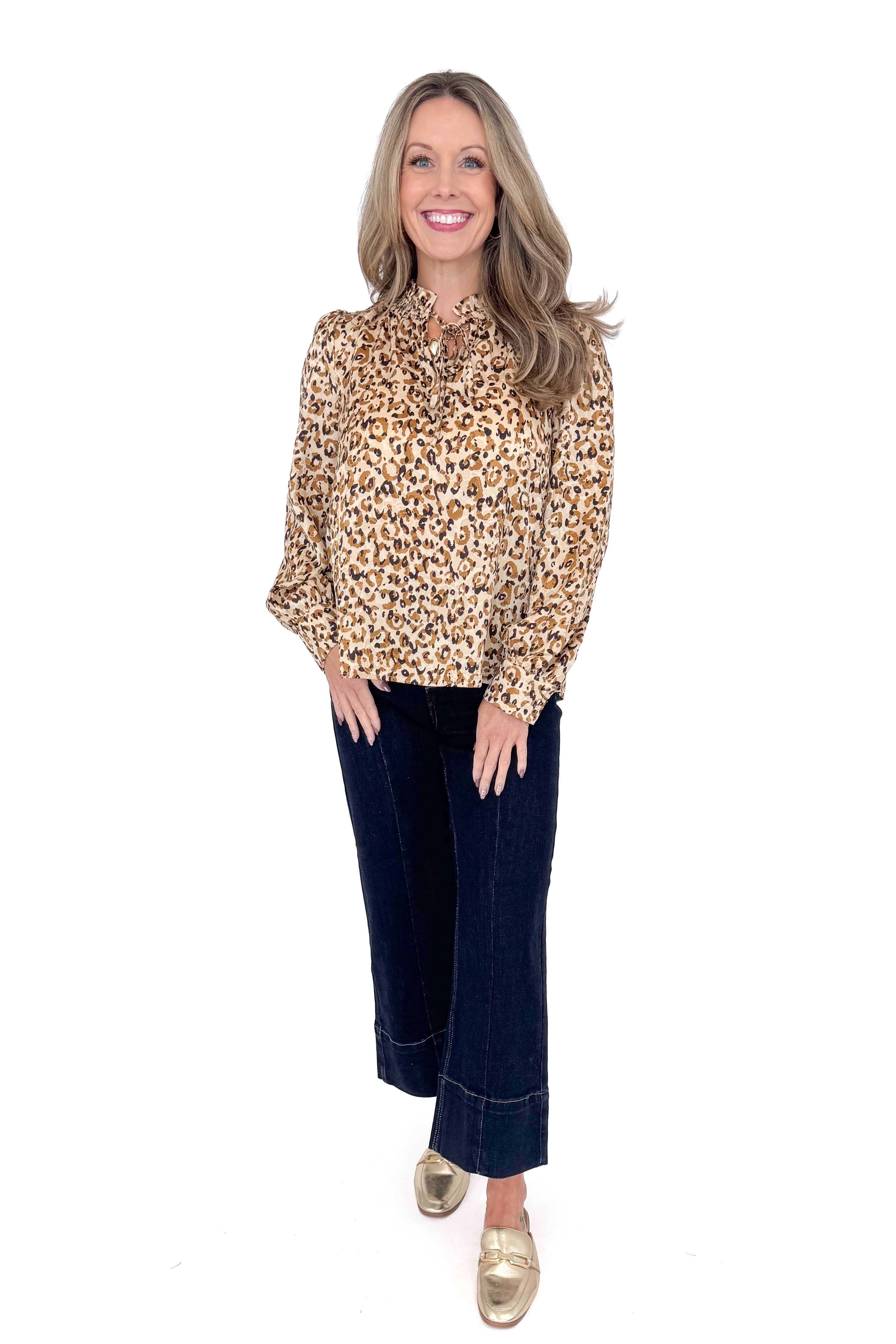 Woman in a studio wearing Taupe Leopard Long Sleeve Top by Fate and jeans against a white background.