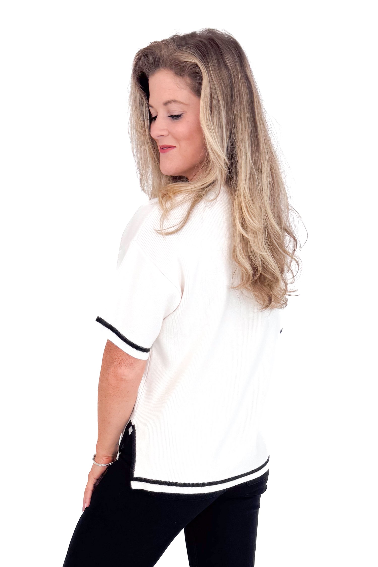 Woman wearing a white shirt with black trim on a white background