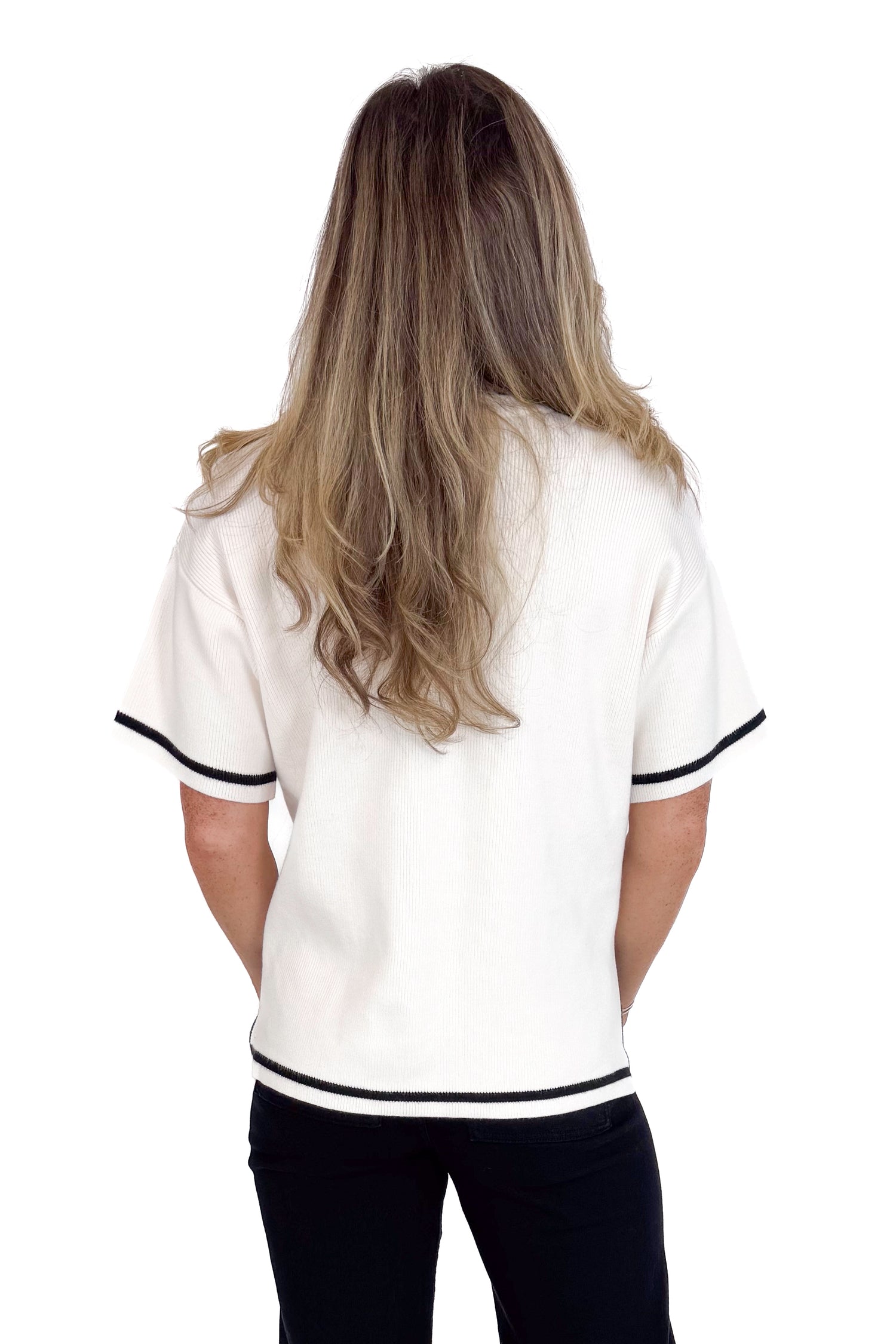 Person wearing a white shirt with black trim on a white background
