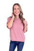 Woman wearing a pink sweater and blue jeans on a white background