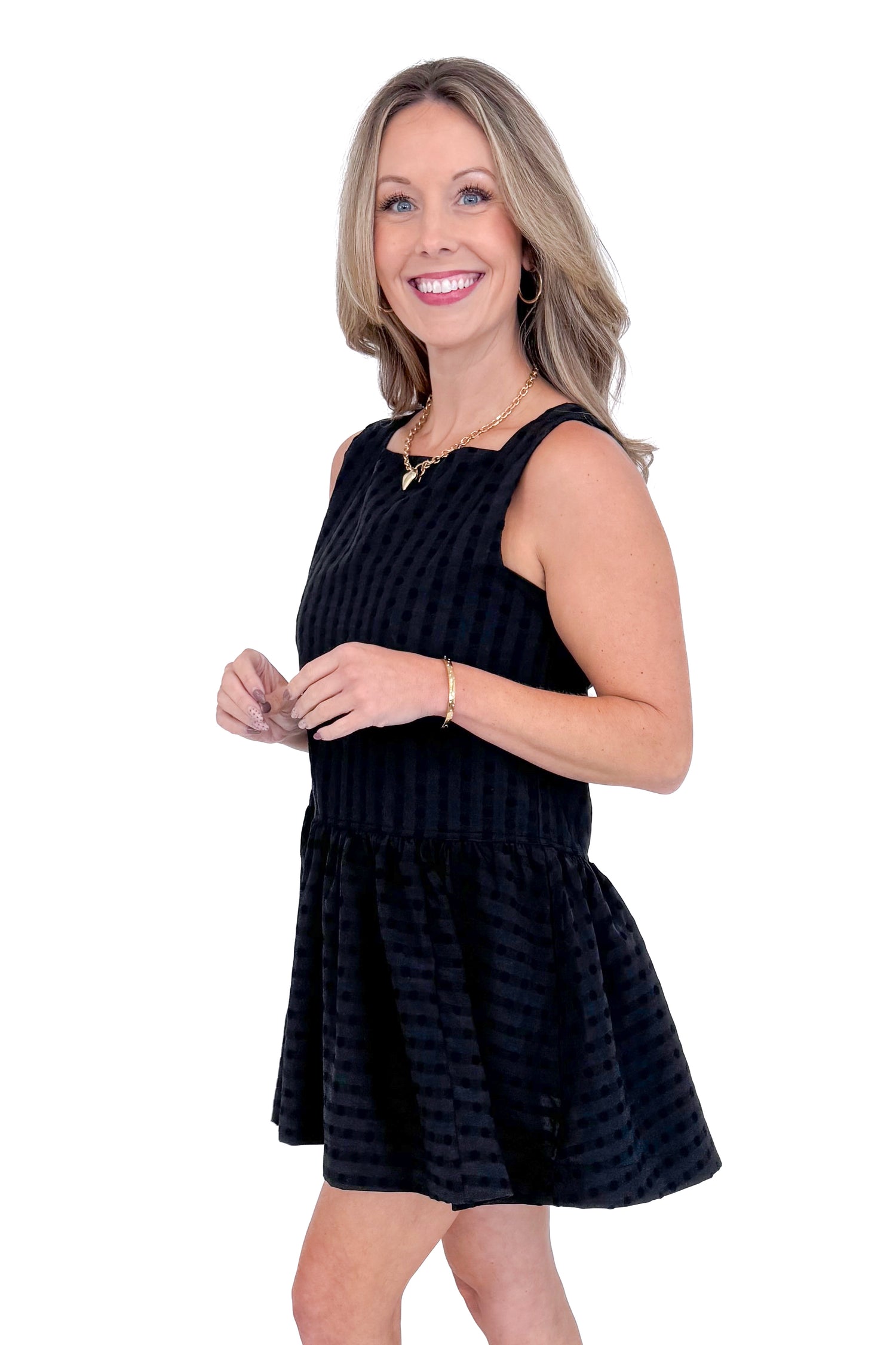 Side view of Woman wearing Black Square Neck Polka Dot Detail Dress against a white studio background.