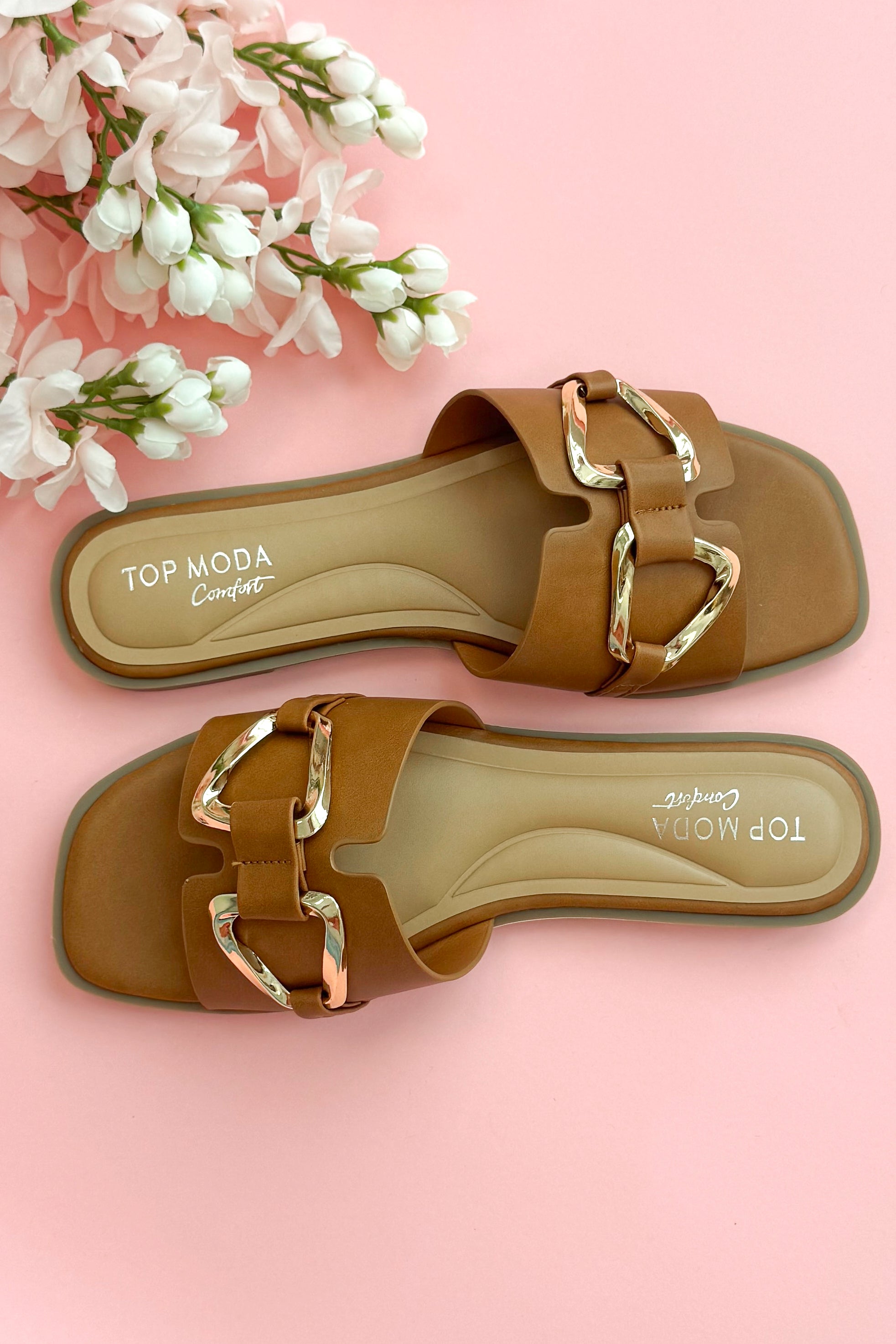 Top view of Gelato- Tan Buckle Detail Sandals against pink studio background.