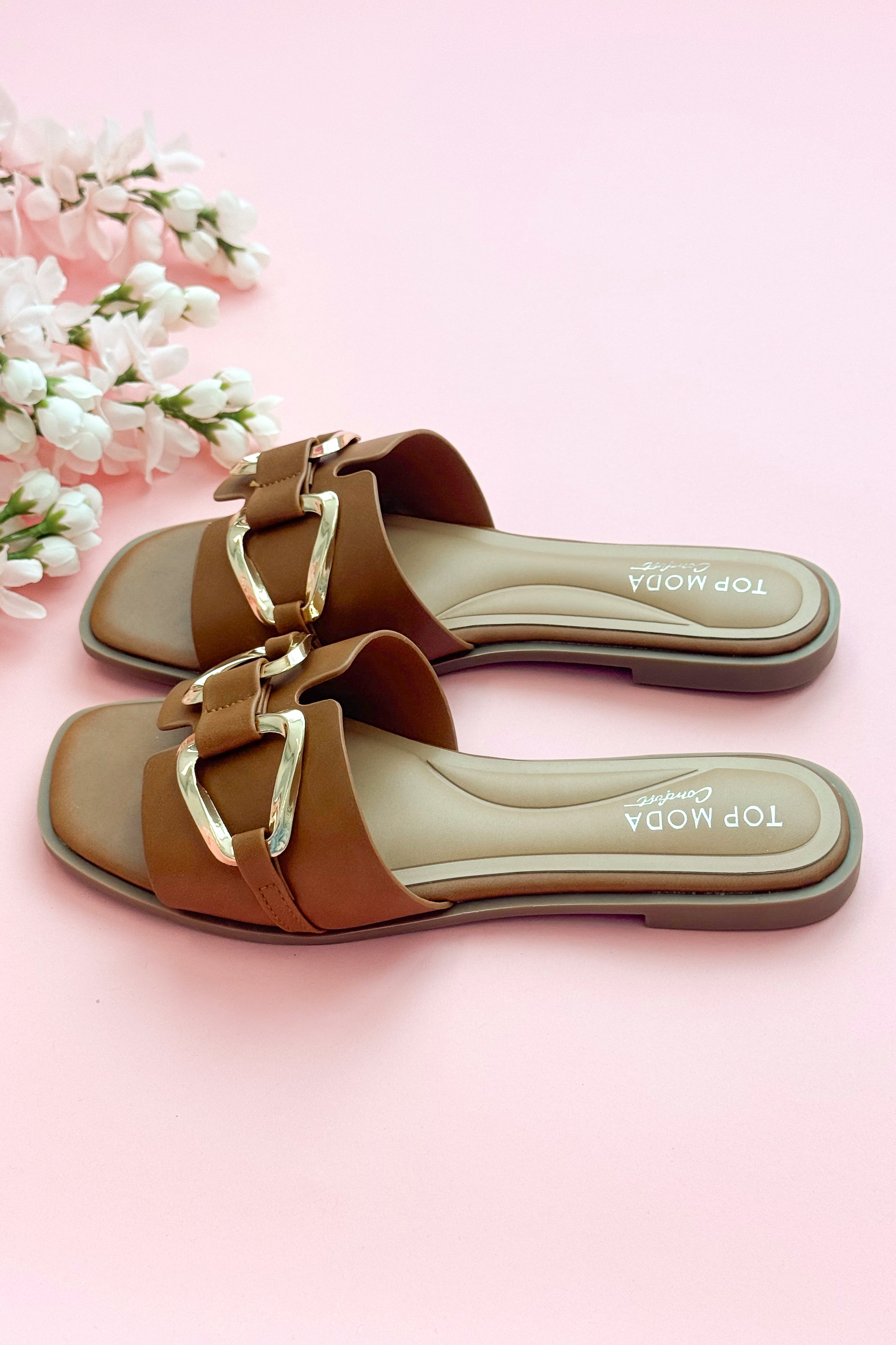 Side view of Gelato- Tan Buckle Detail Sandals against pink studio background.