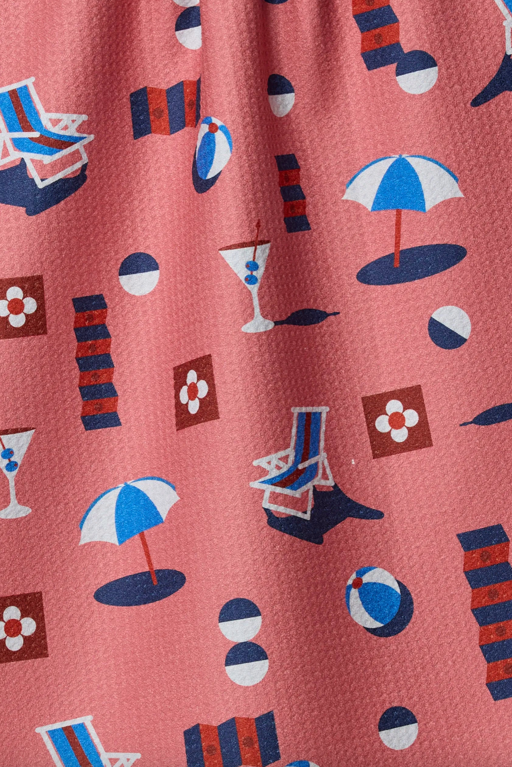 Pattern of beach chairs, umbrellas, and balls on a light red background