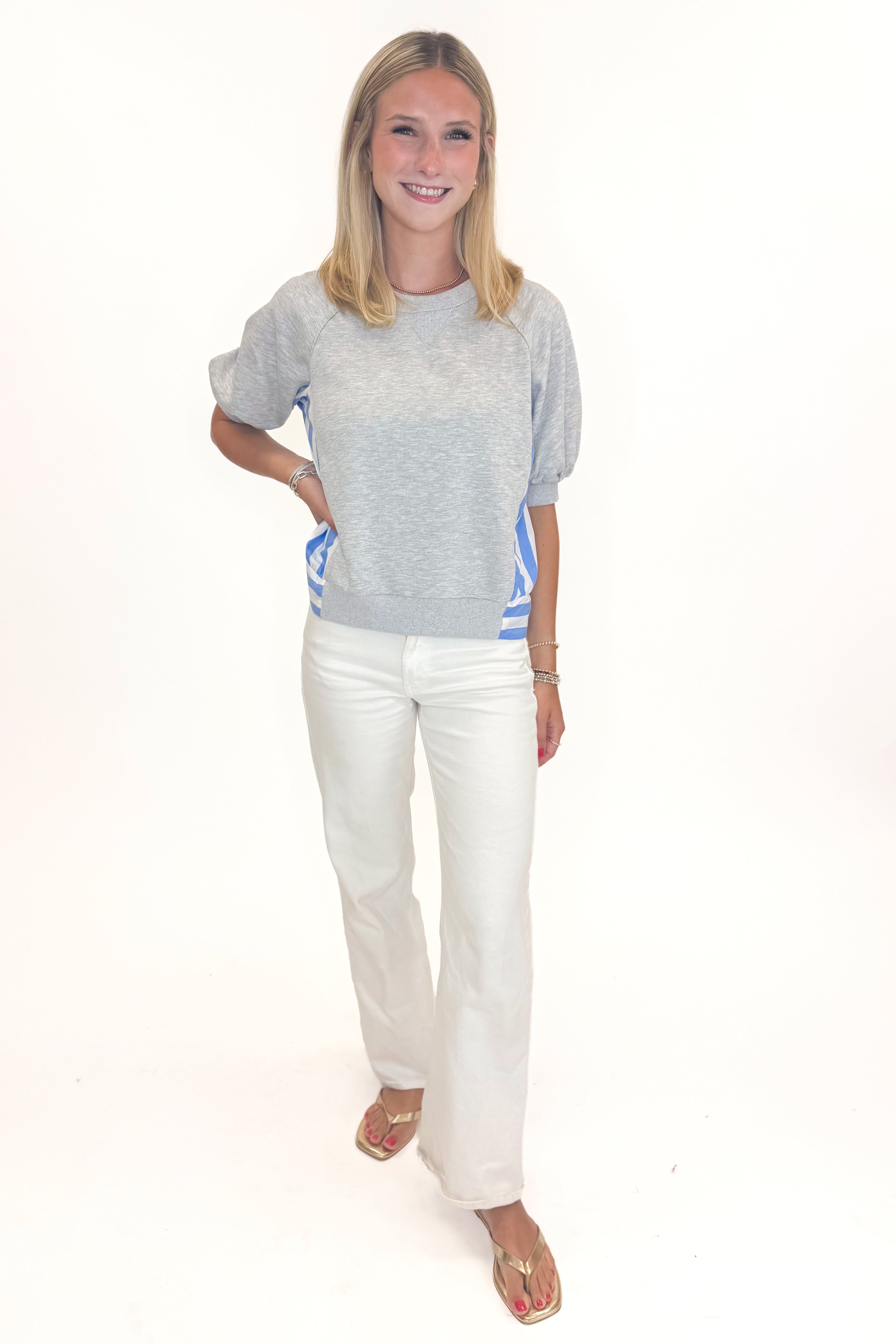 Front view of woman wearing Swagger Boutiqueās Grey Striped Short Sleeve Sweatshirt with jeans against white studio background.