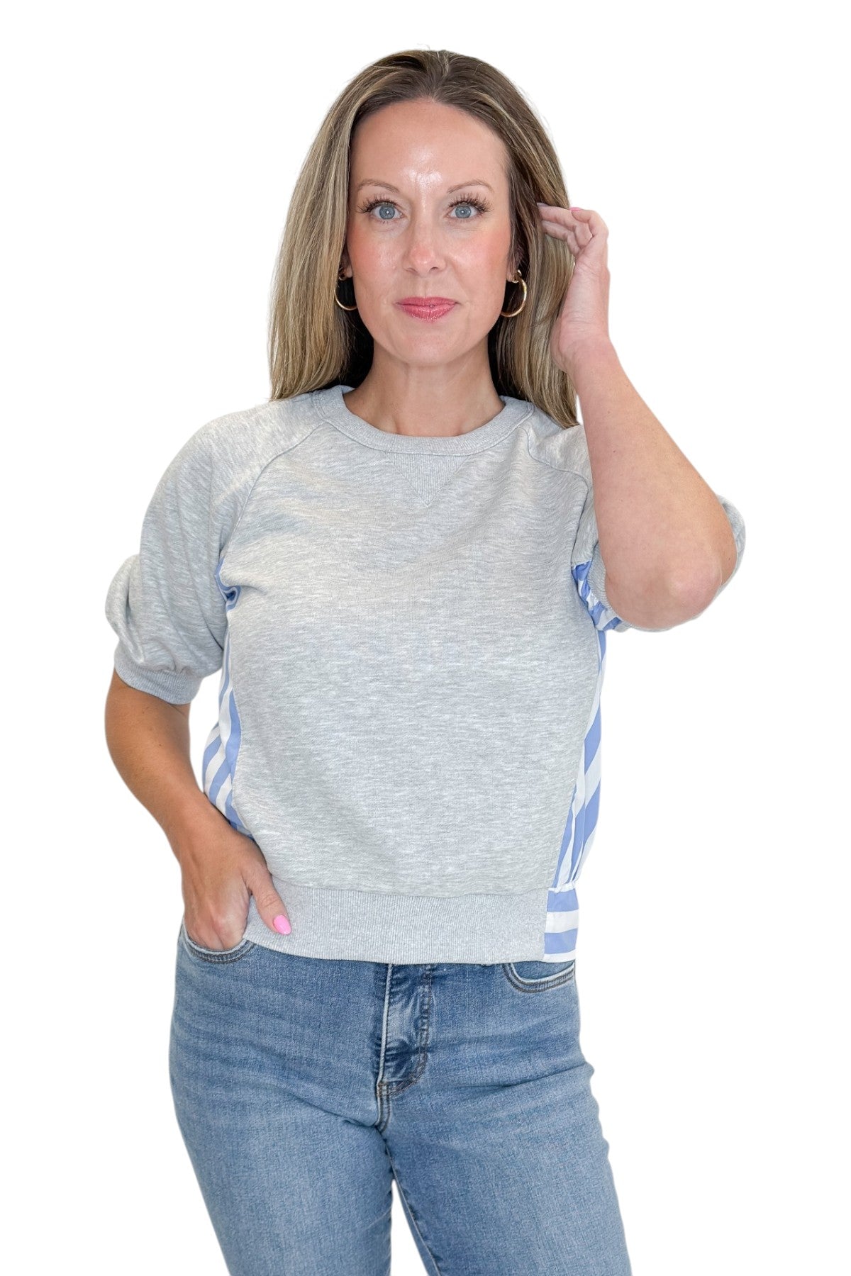 Front view of woman wearing Swagger Boutiqueās Grey Striped Short Sleeve Sweatshirt with jeans against white studio background.