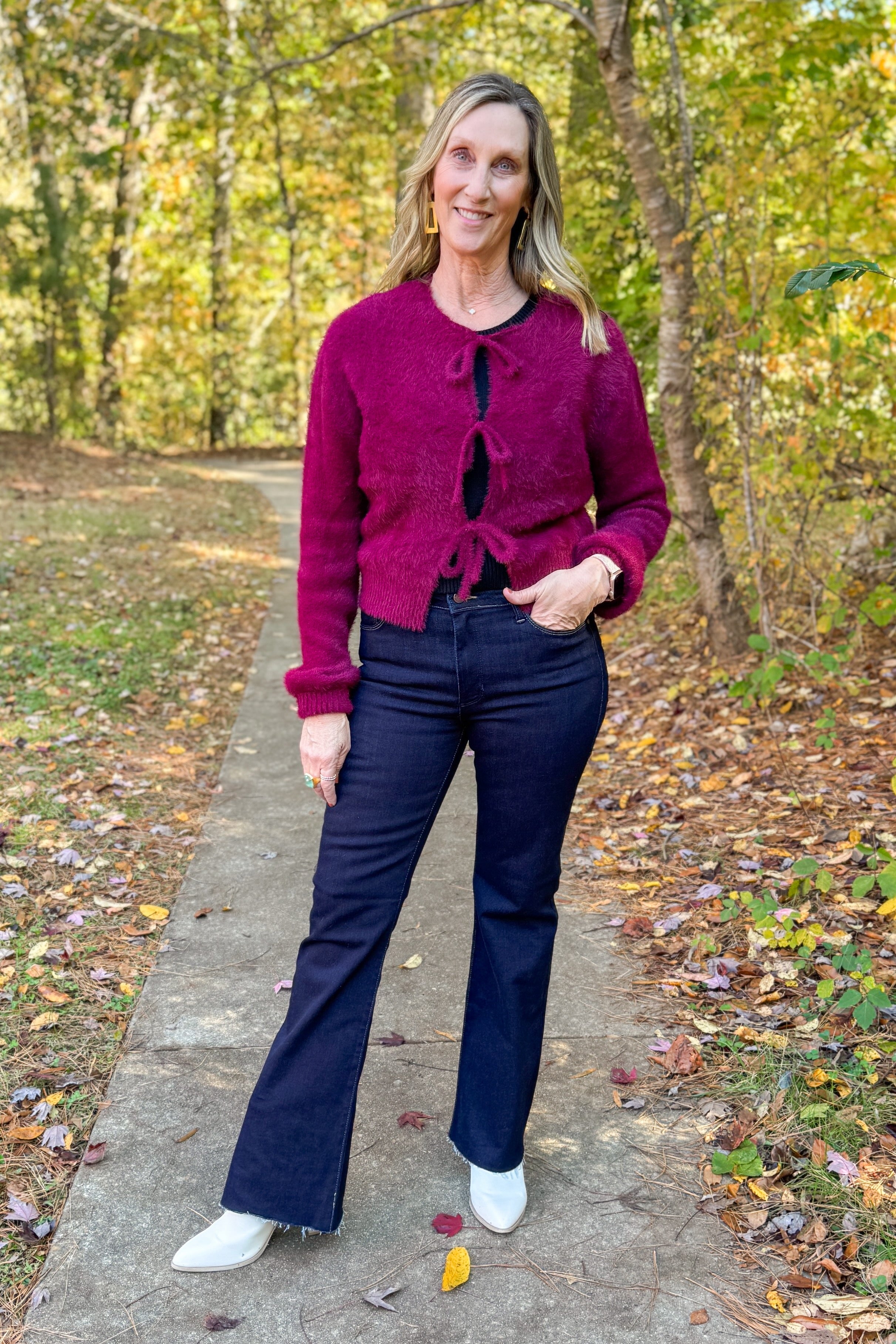 Front view of woman wearing Wine Eyelash Tie Detail Cardigan with jeans outside.