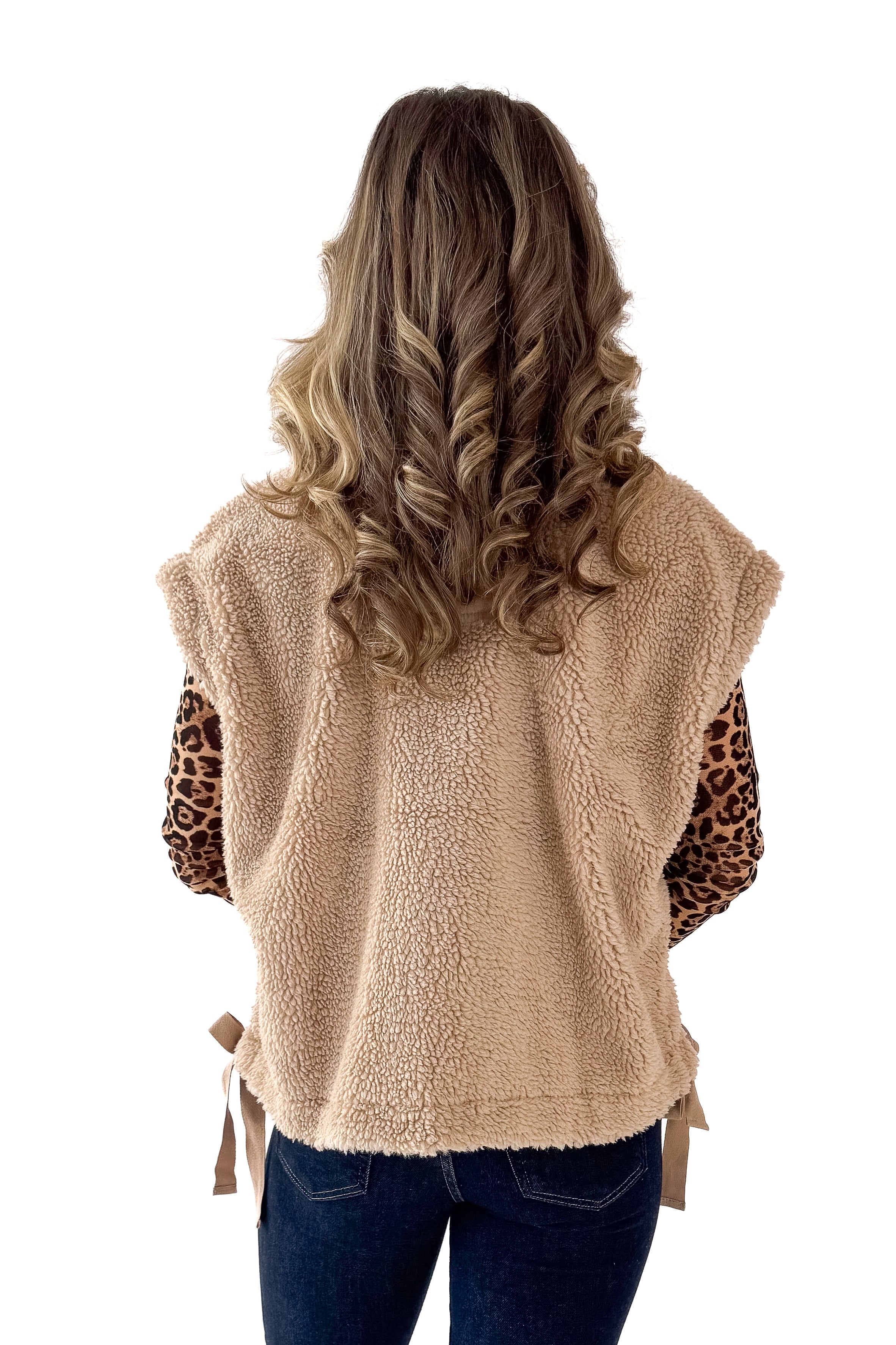 Back view of woman wearing Taupe Sherpa Button Up Vest with jeans against white studio background.
