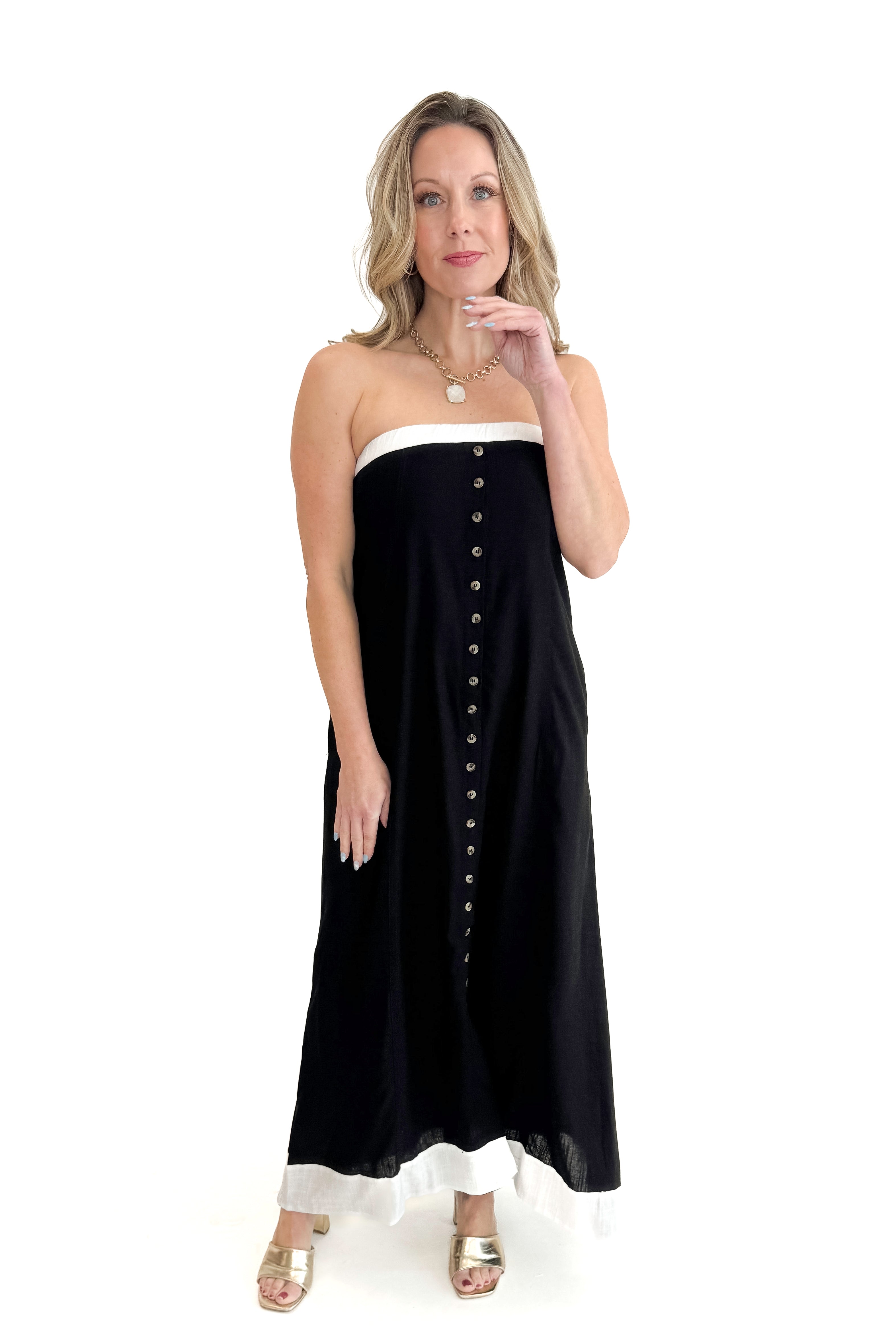 Front view of woman wearing Black With White Lining Button Down Strapless Dress against white studio background.
