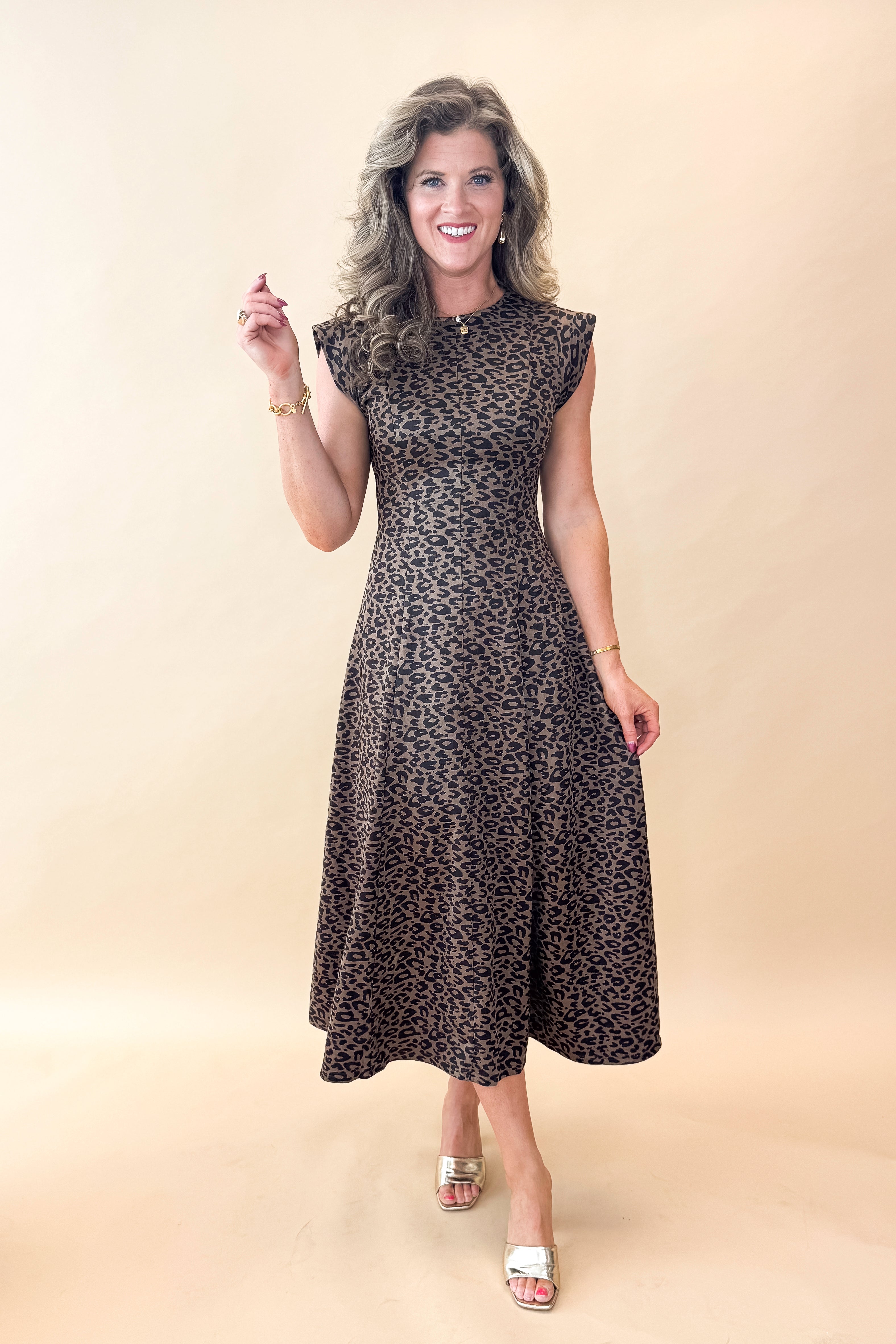Front view of woman wearing Leopard Suede Midi Dress against tan studio background.