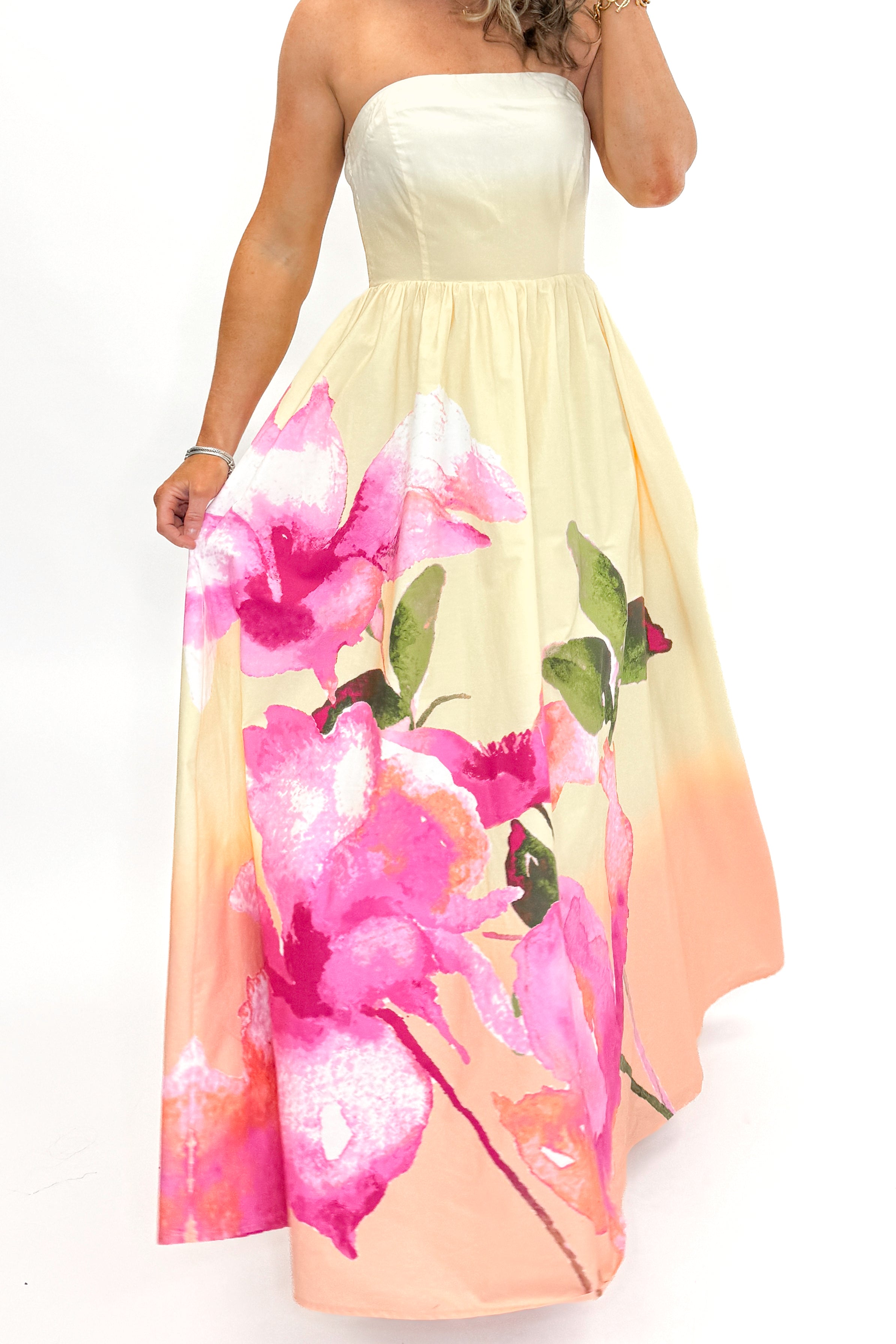 Front detail view of woman wearing Yellow & Pink Floral Print Strapless Maxi Dress against white studio background.