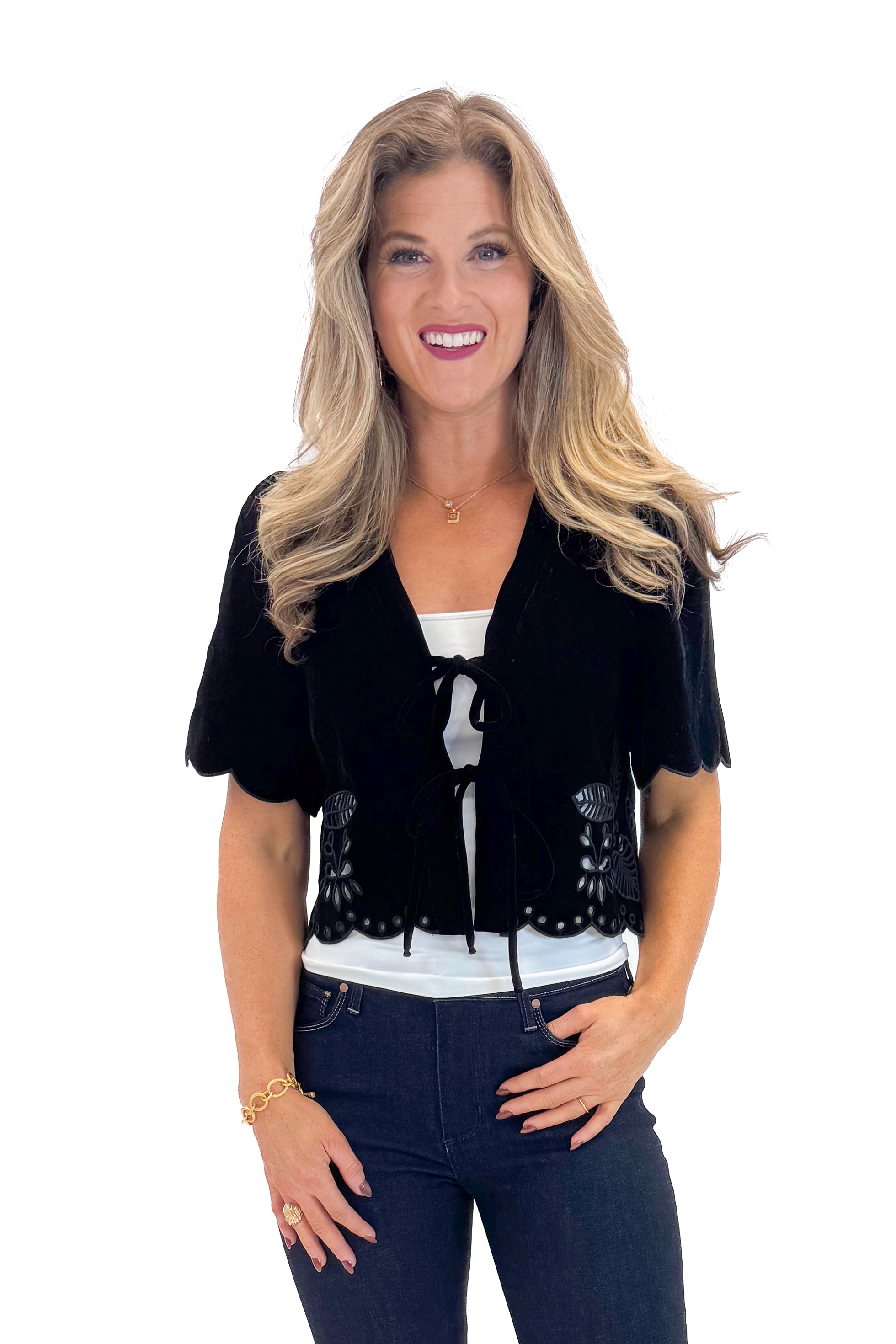 Front view of woman wearing Black Velvet Tie Front Top with jeans against white studio background.
