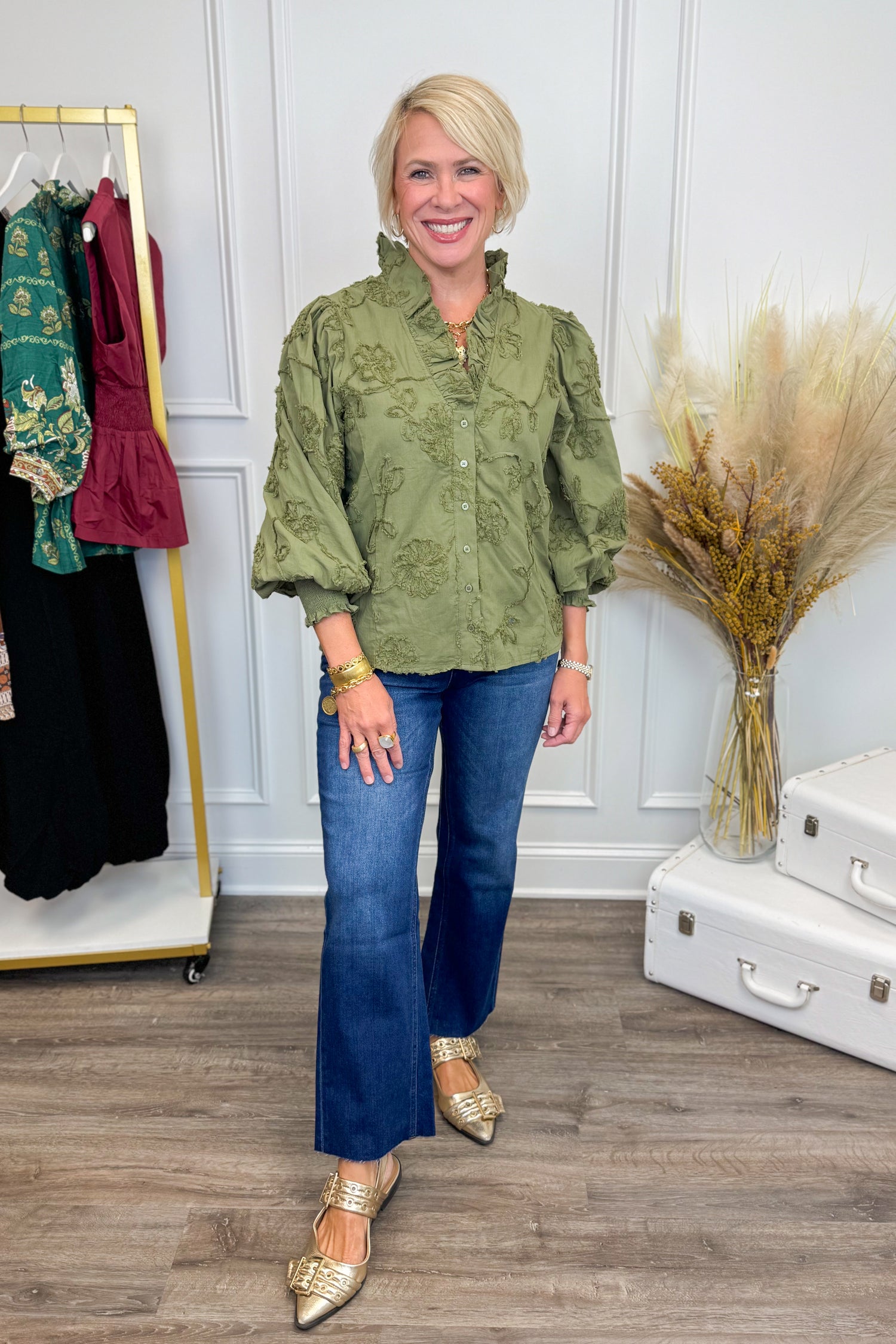 Woman wearing Pick Me Olive Floral Applique Ruffle Detail Top - front view showing floral applique design and ruffle detailing in olive green