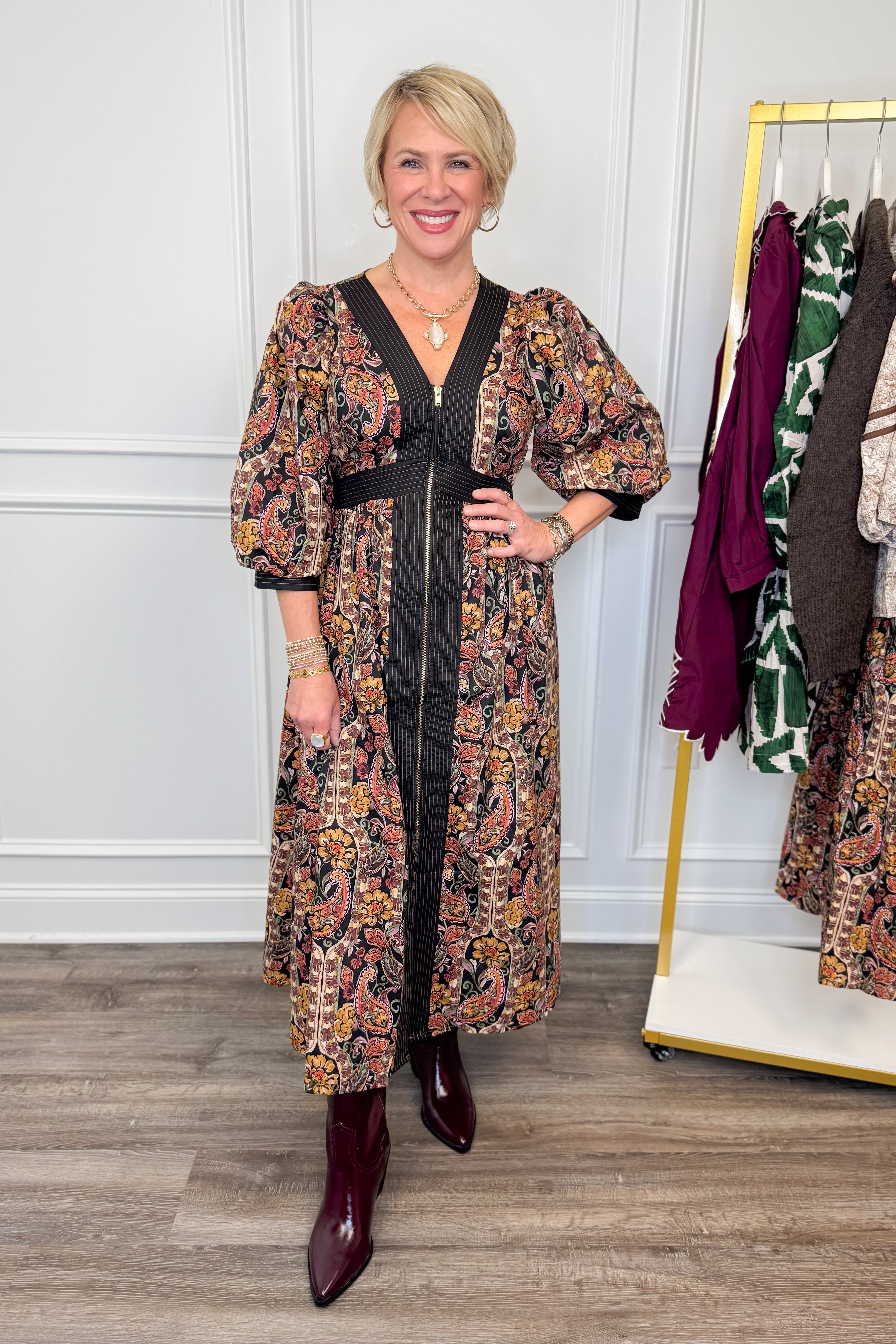 woman wearing multi printed midi dress with center zipper and burgundy boots