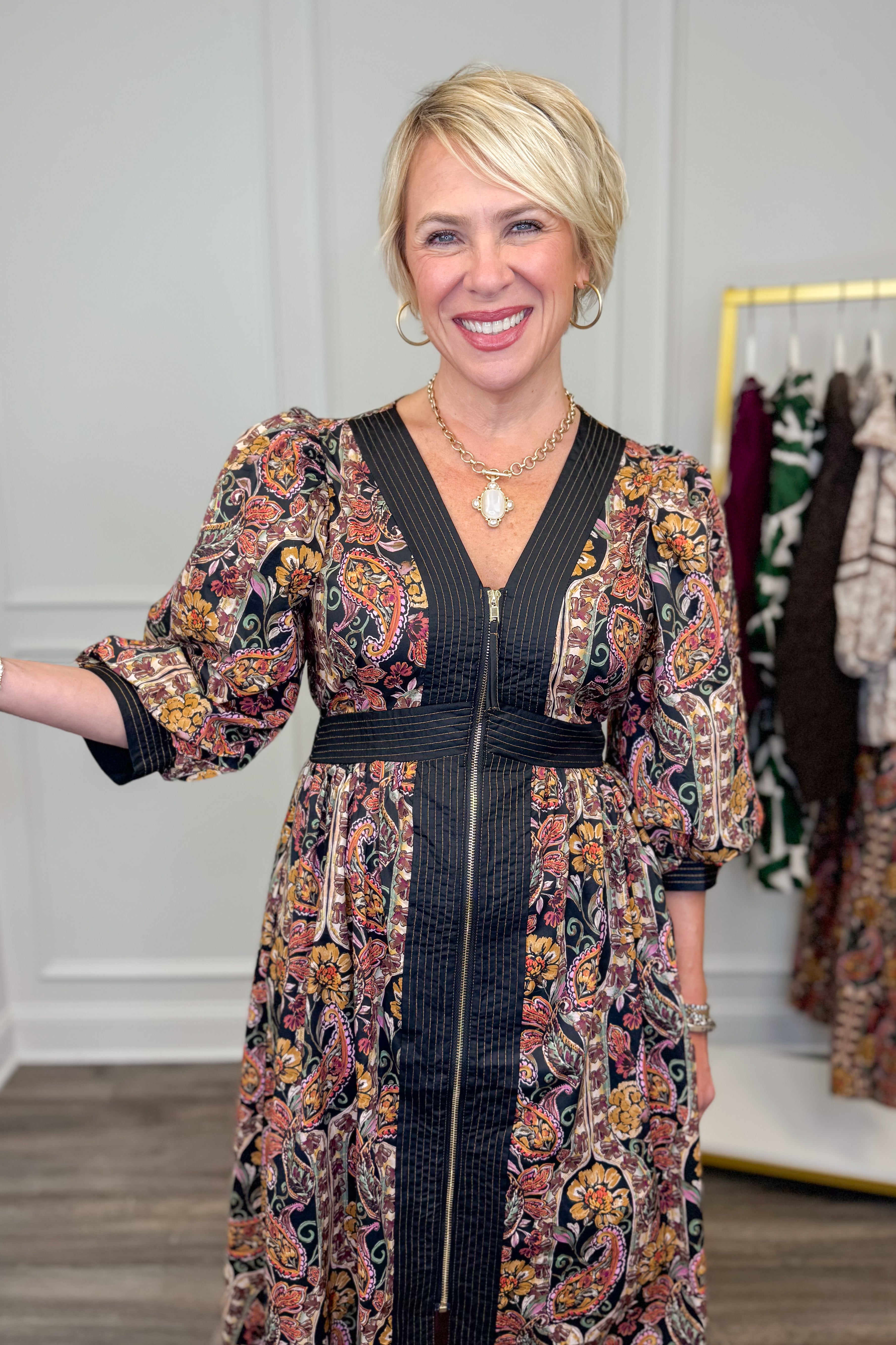 woman wearing multi printed midi dress with center zipper and burgundy boots
