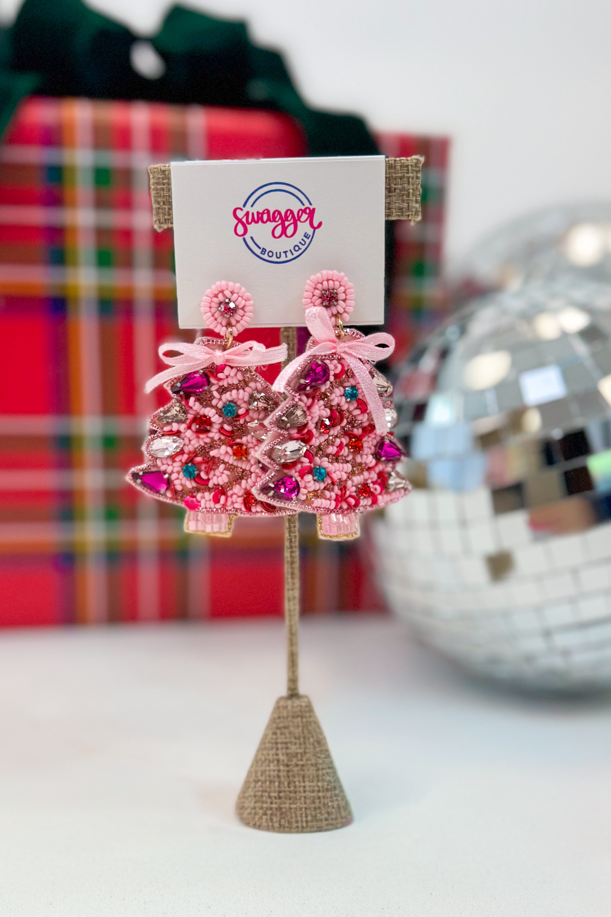 Pink beaded earrings on a stand with a &