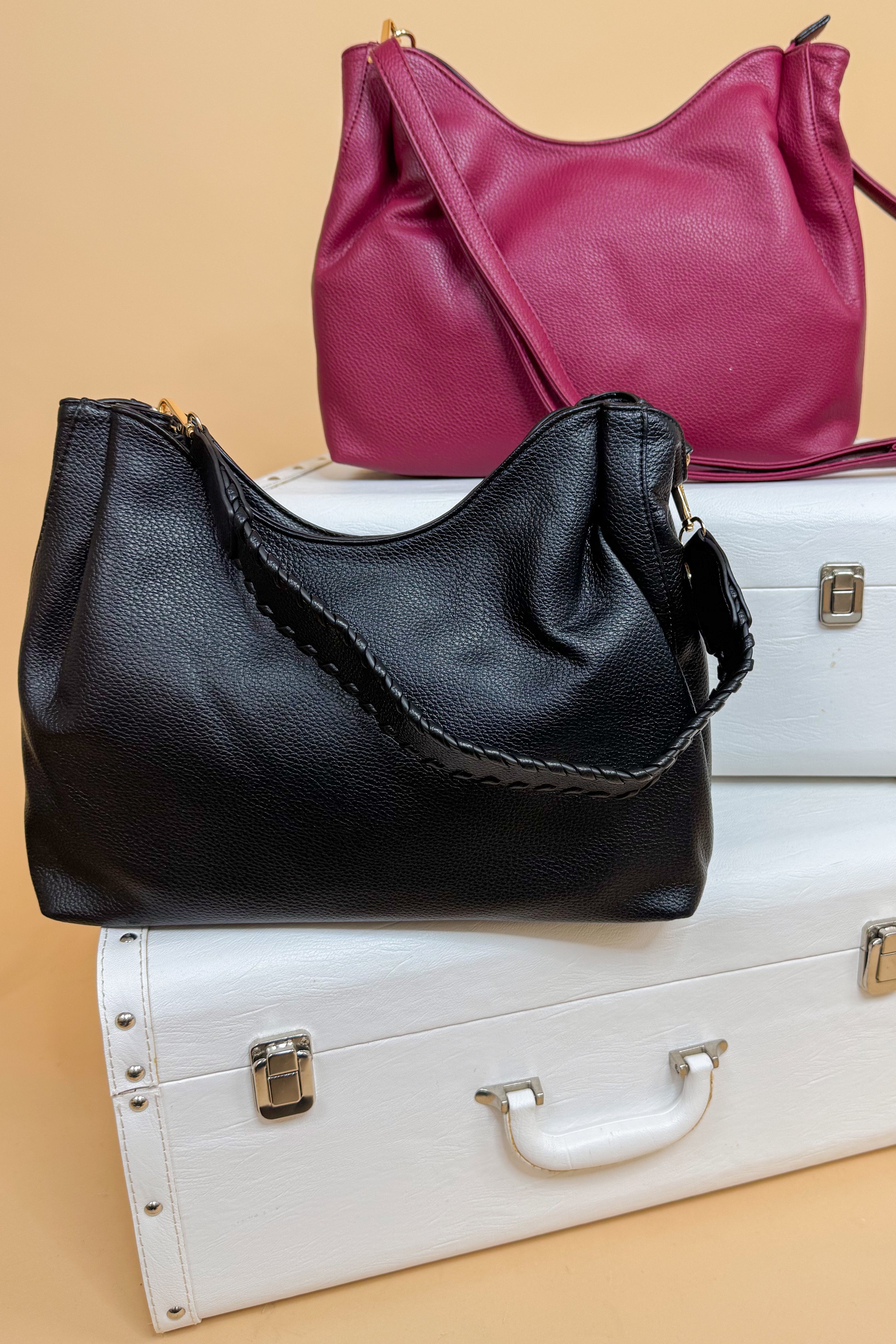 Black and pink handbags on a beige background