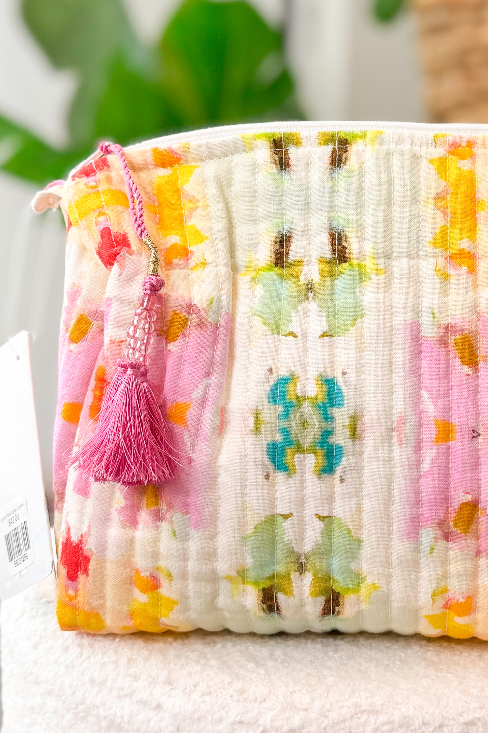Floral-patterned fabric with tassel on a white surface
