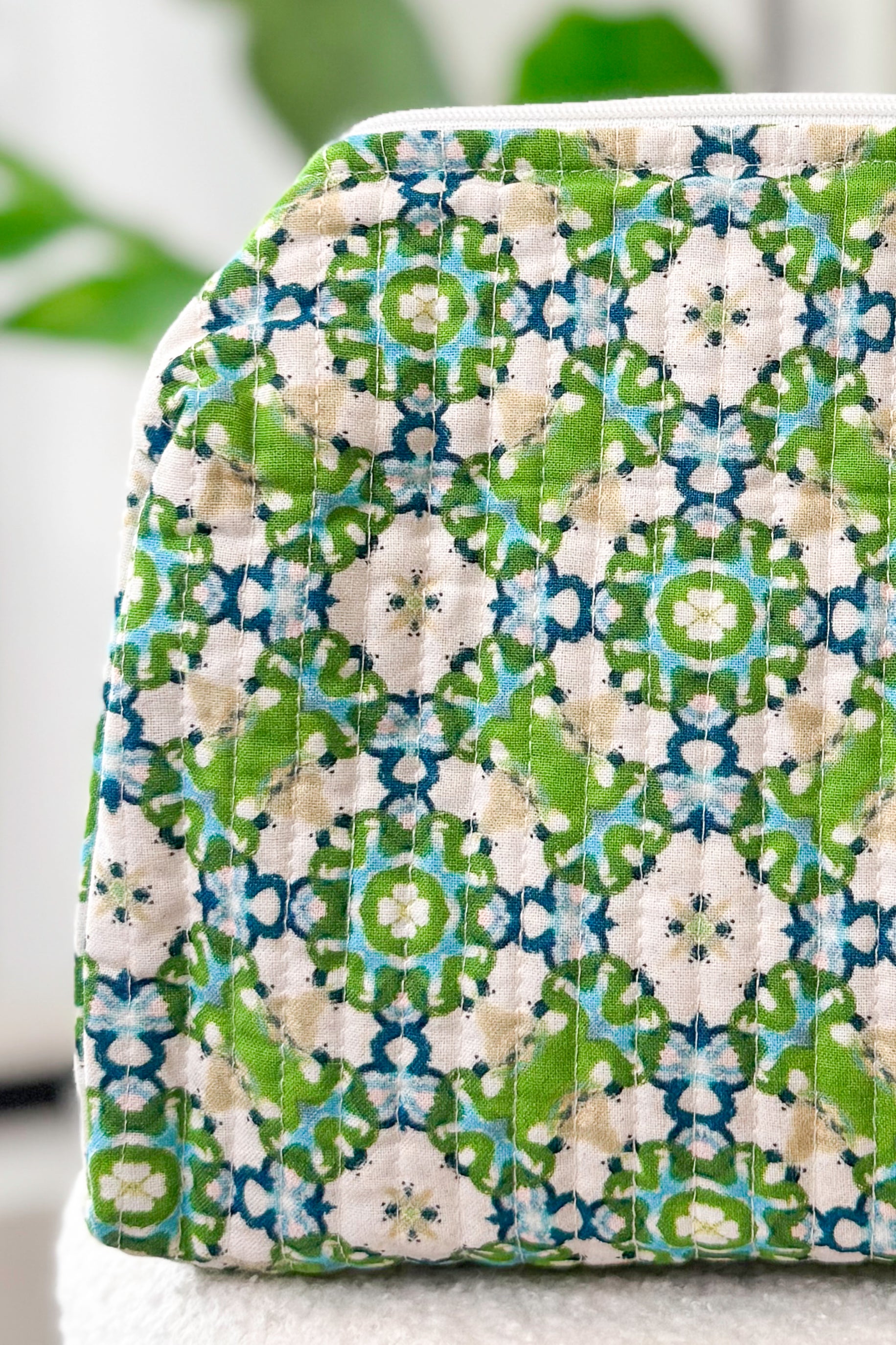 Fabric pouch with green and blue pattern on a white background