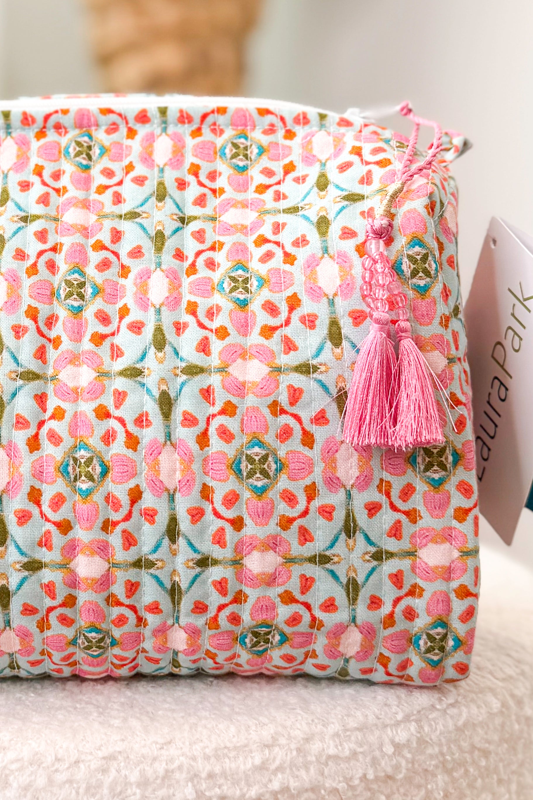 Patterned product with a pink tassel on a neutral background