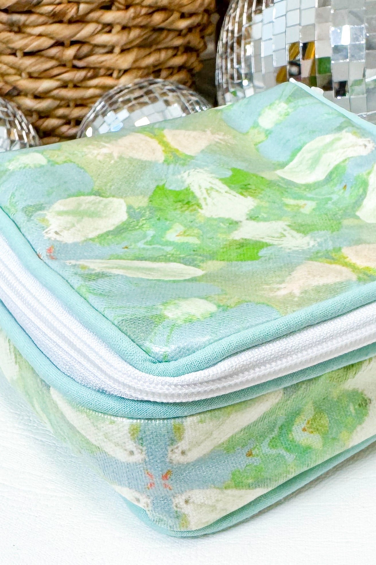 Green floral-patterned case with a zipper on a white surface