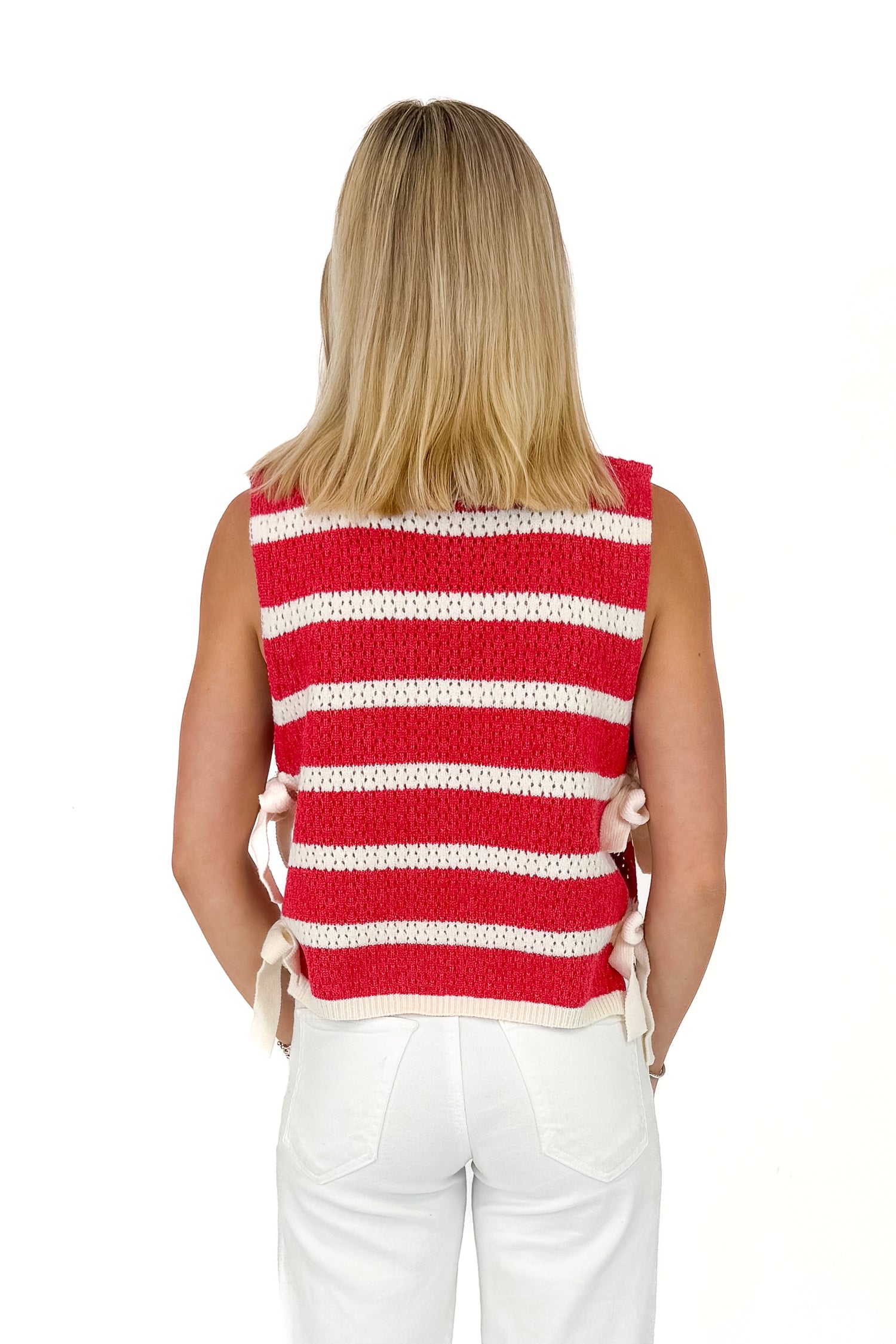 Person wearing a red and white striped sleeveless top on a white background