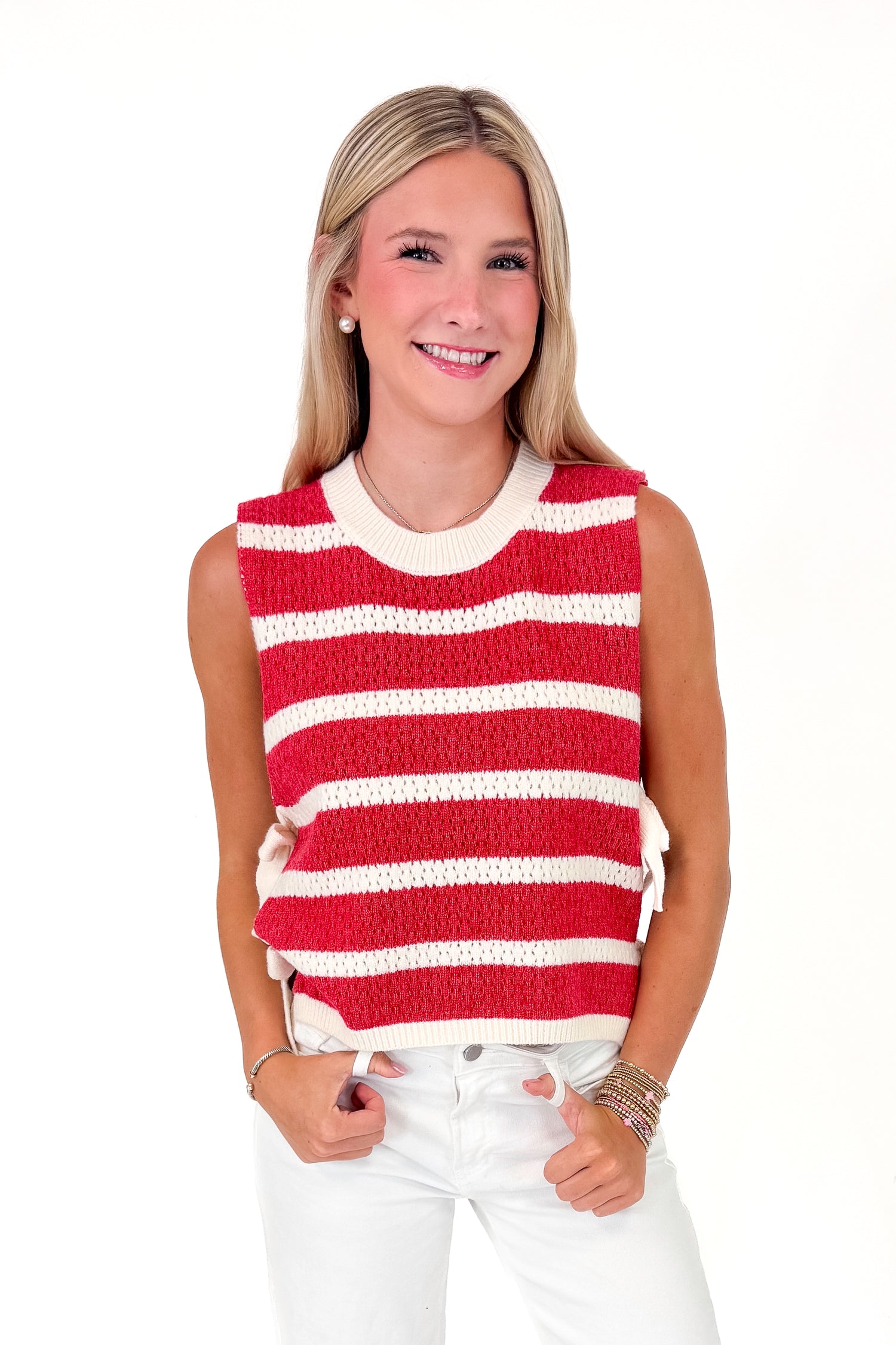 Woman wearing a red and white striped sleeveless top on a white background