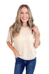 Woman wearing a beige sweater and blue jeans on a white background