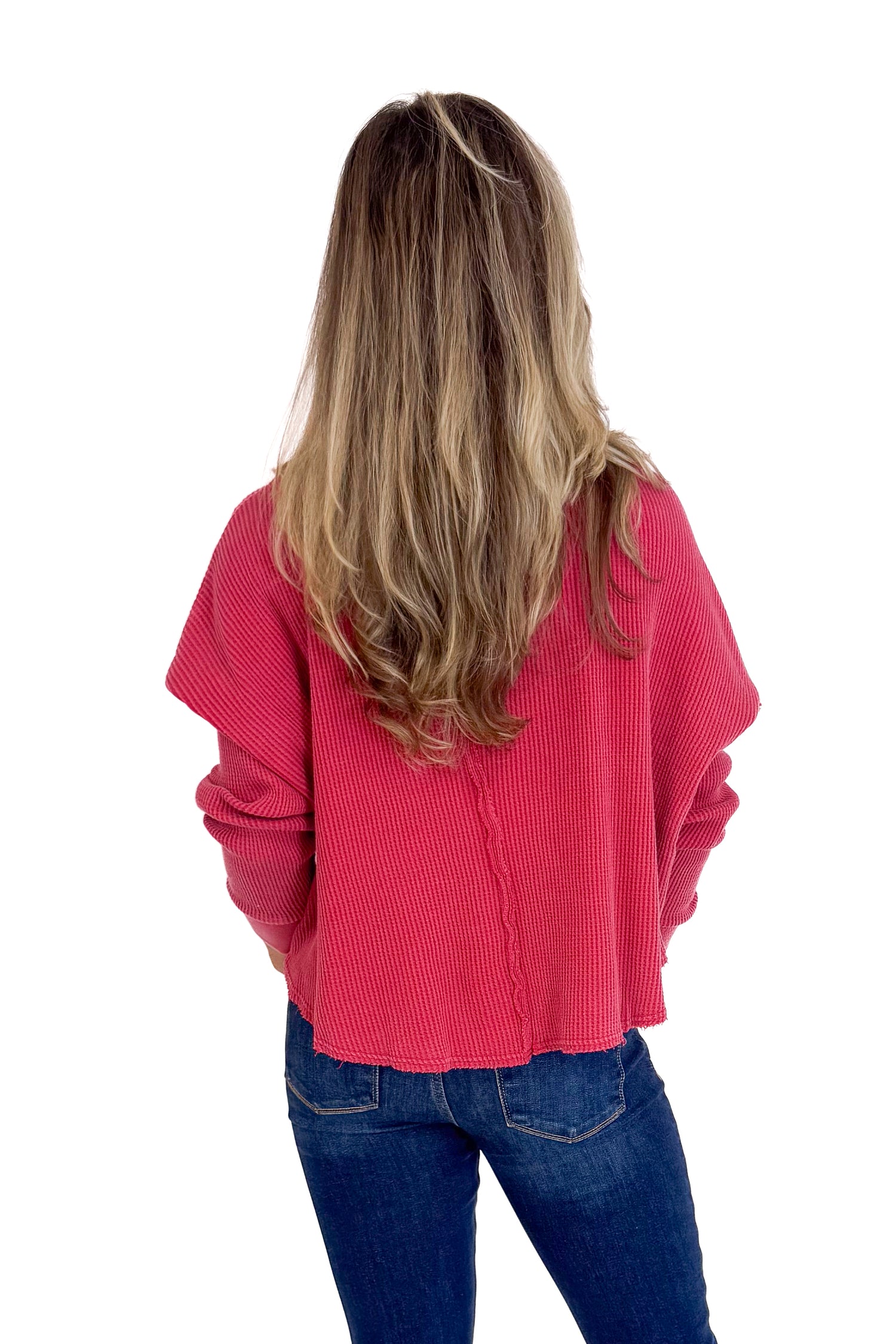Person wearing a red sweater and blue jeans on a white background