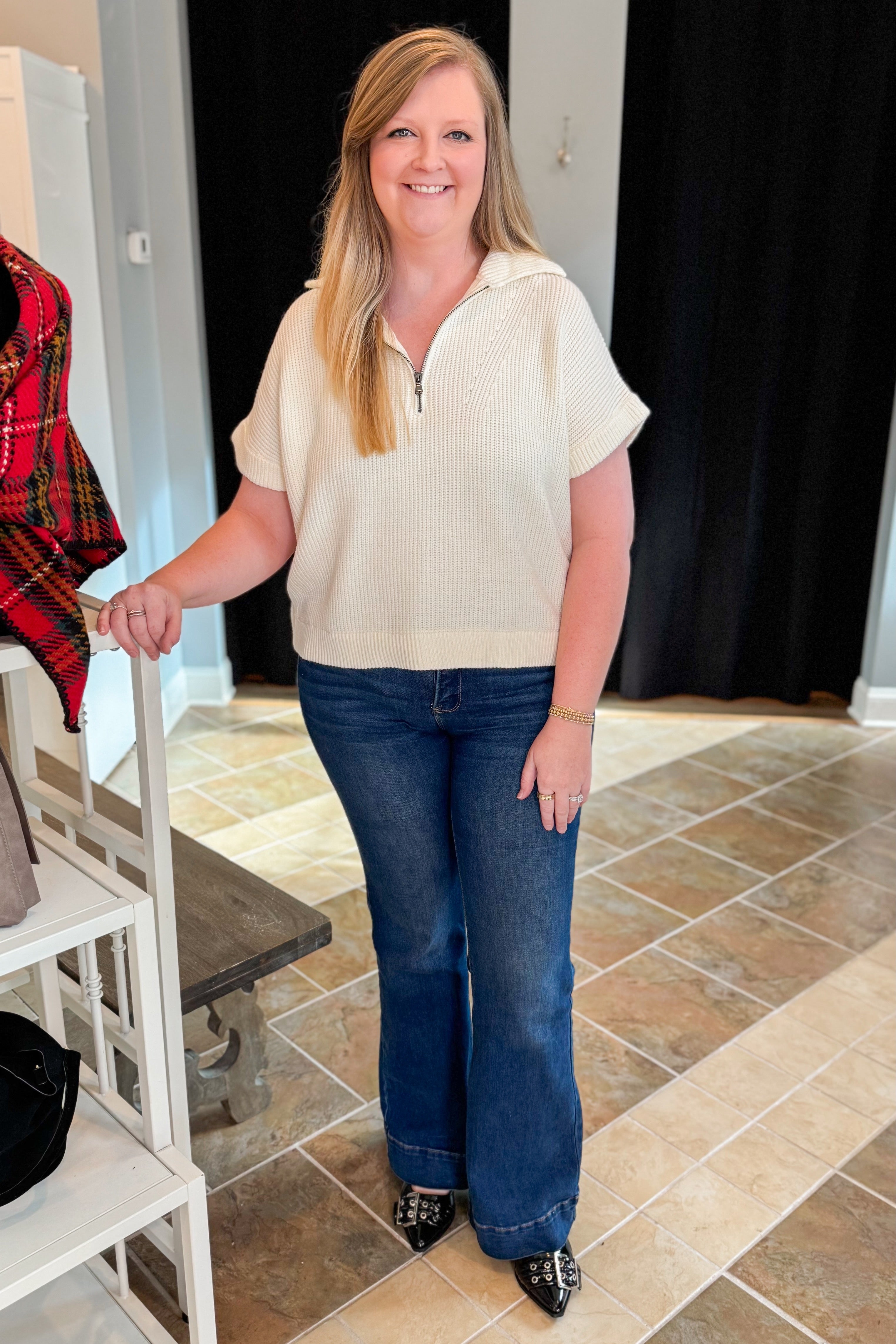 Front view of woman wearing Off White 1/2 Zip Short Sleeve Sweater with jeans at a boutique.
