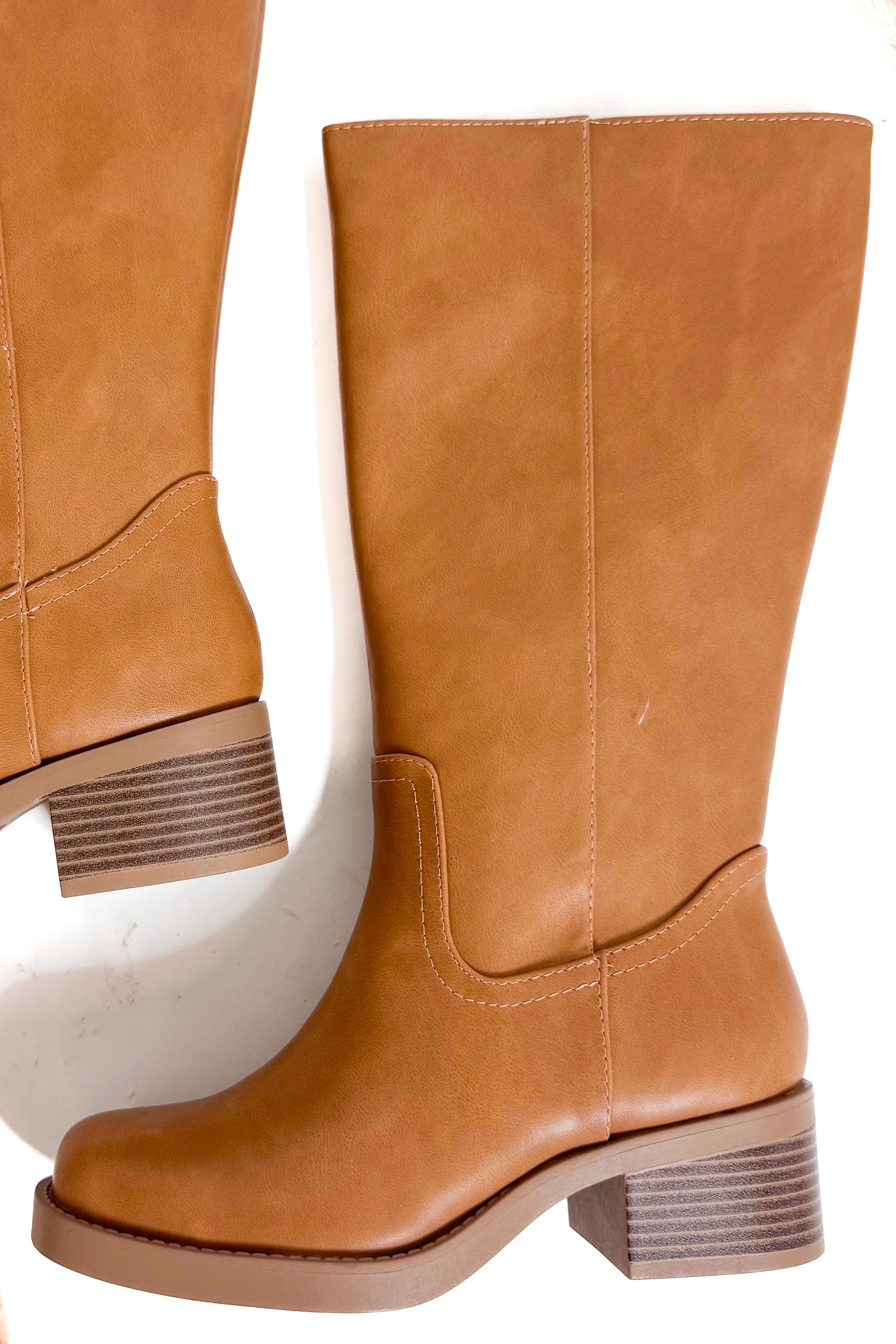 Pair of tan high boots on a white background