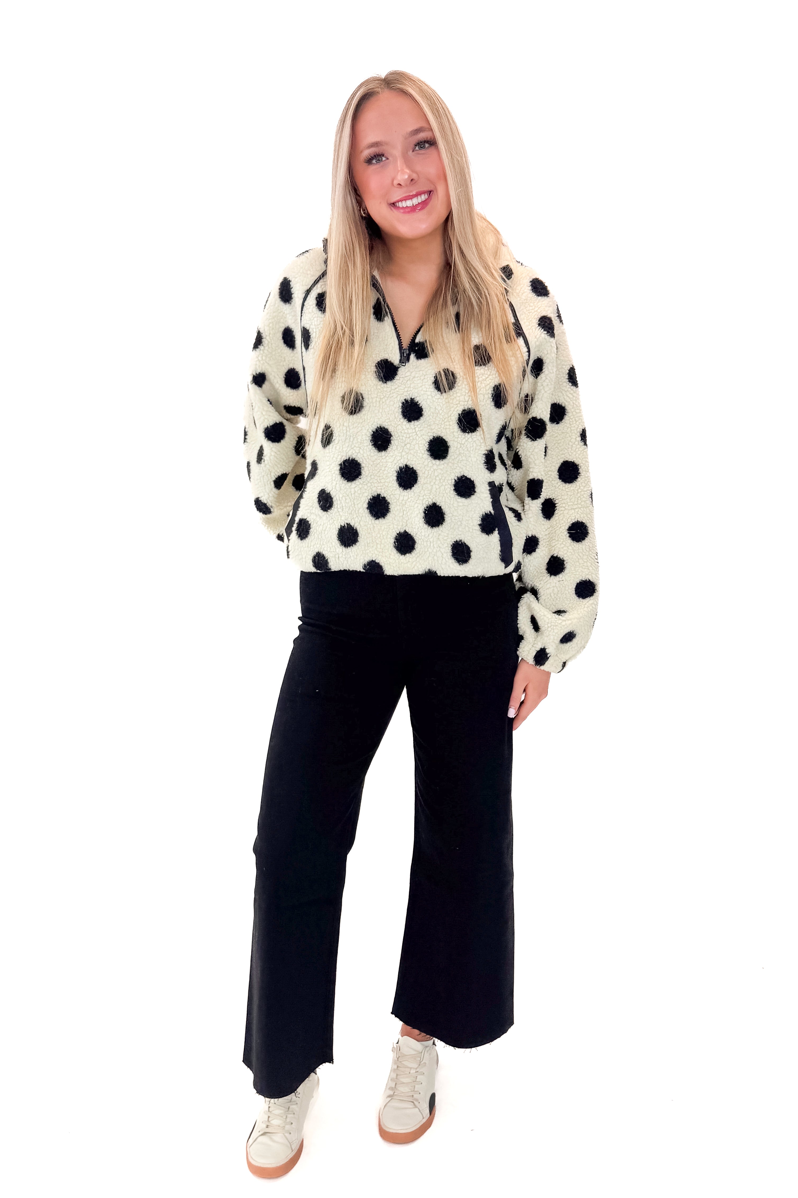 Front view of woman wearing Ivory & Black Polka Dot Sherpa Half Zip Sweatshirt with jeans against white studio background.