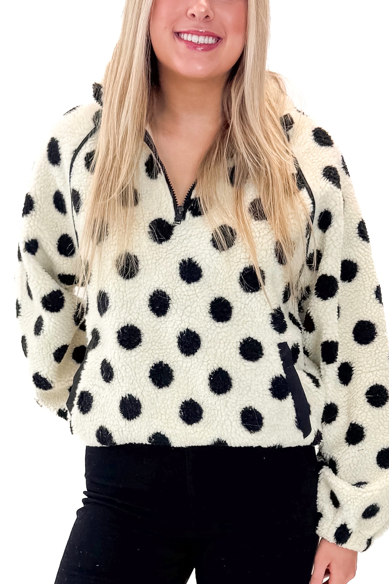 Front detail view of woman wearing Ivory & Black Polka Dot Sherpa Half Zip Sweatshirt with jeans against white studio background.