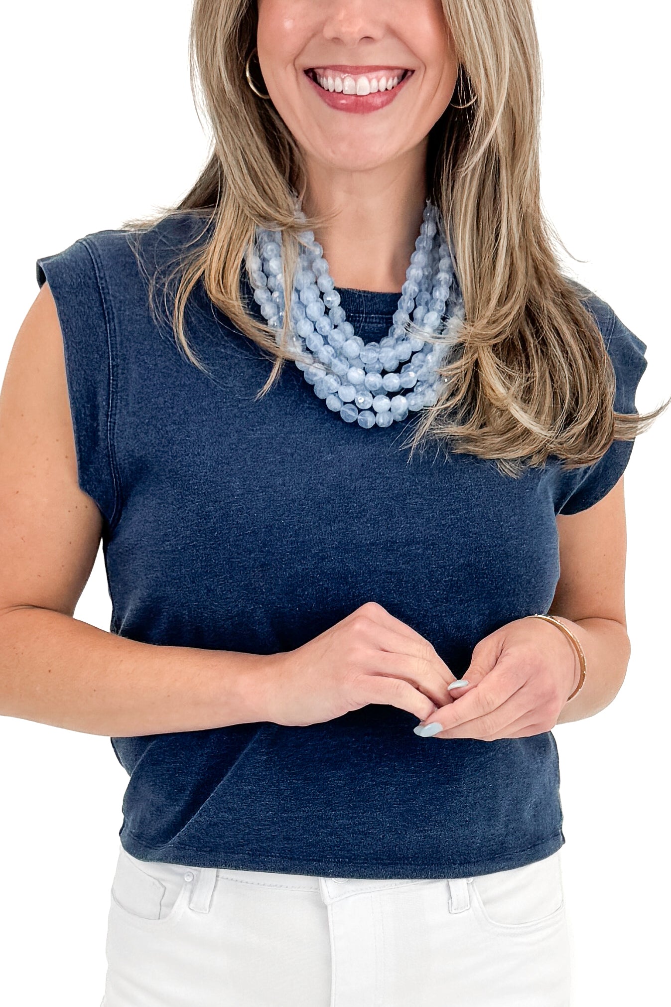 Front detail view of woman wearing Indigo Camino Jersey Denim Top by Z Supply with jeans against white studio background.