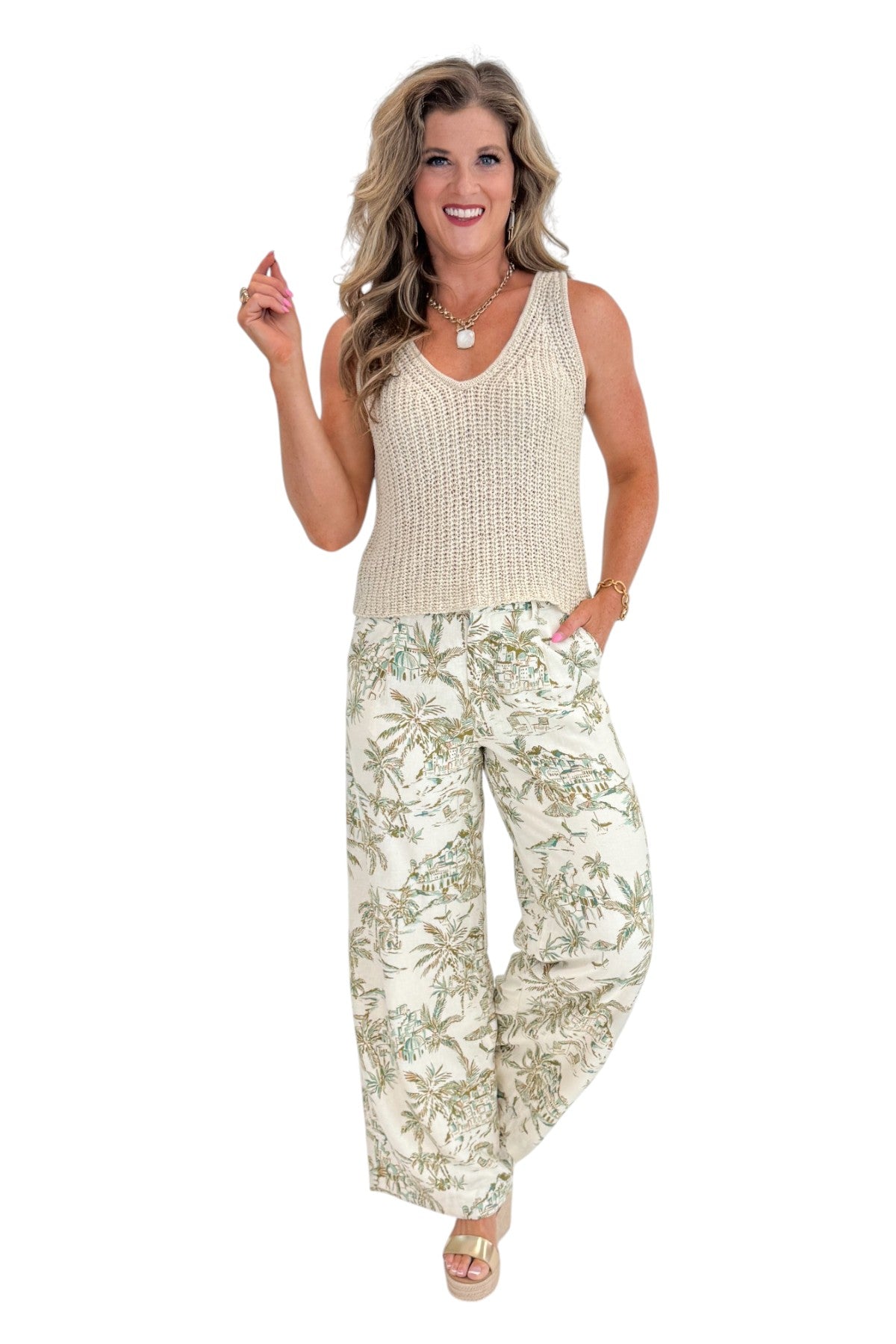 Front view of woman wearing Swagger Boutique’s Island Coconut Overlook Tiki Tide Linen Pants with Beige V-Neck Knitted Tank by Skies Are Blue against white studio background.