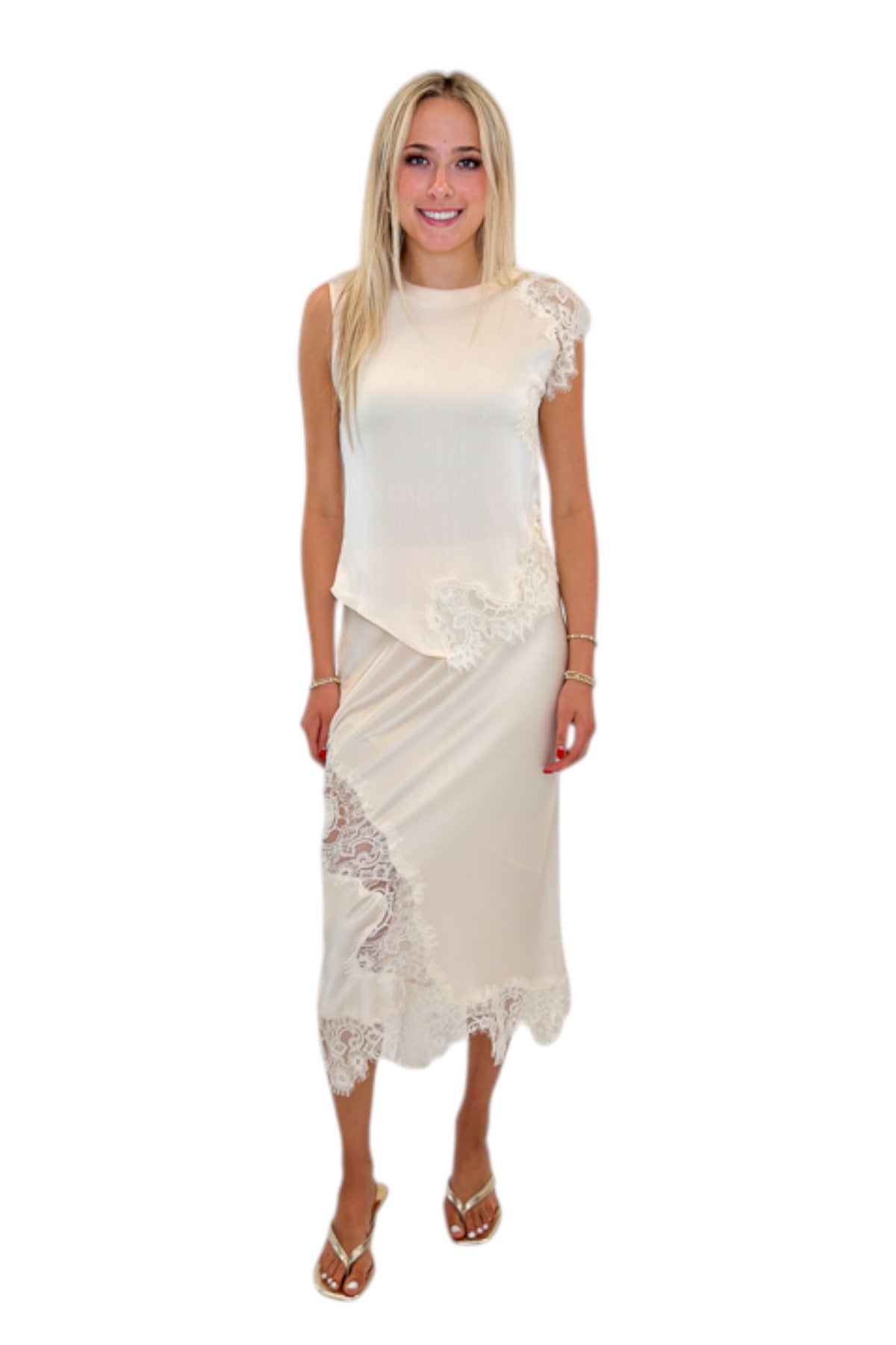 Front view of woman wearing Swagger Boutique’s Ivory Satin Lace Sleeveless Top with Ivory Satin Lace Midi Skirt against white studio background.