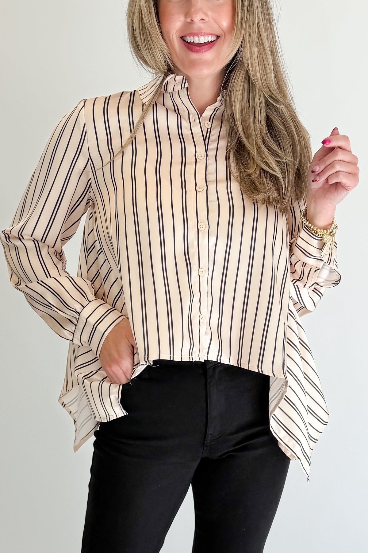 Front detail view of woman wearing Swagger Boutique’s Ivory & Black Striped Satin Top with jeans against white studio background.