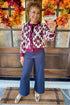 Woman toasting in Wine Floral Printed Button Up Cardigan by Entro and jeans outside.