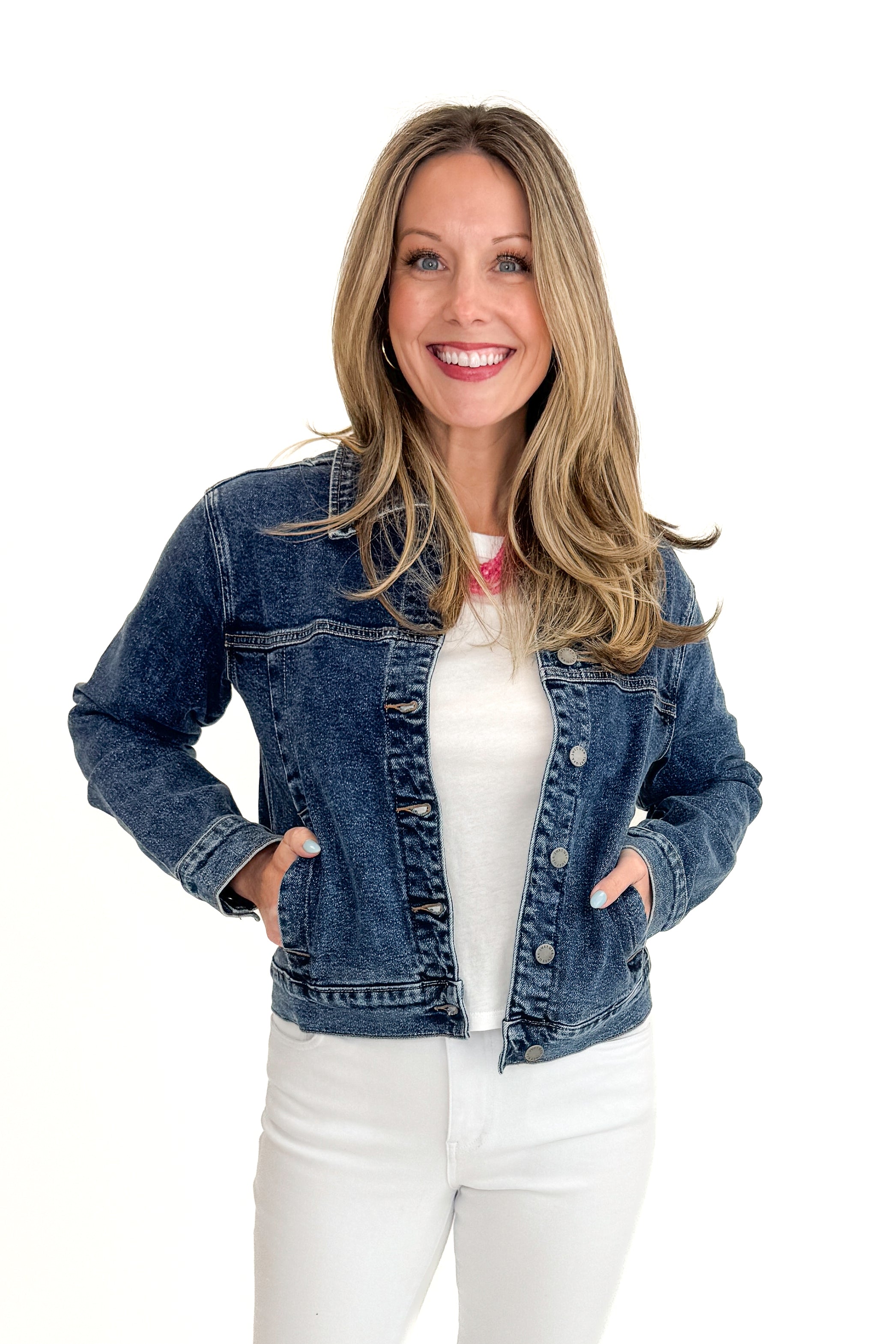 Front view of woman wearing Dark Wash Denim Jacket with jeans against white studio background.