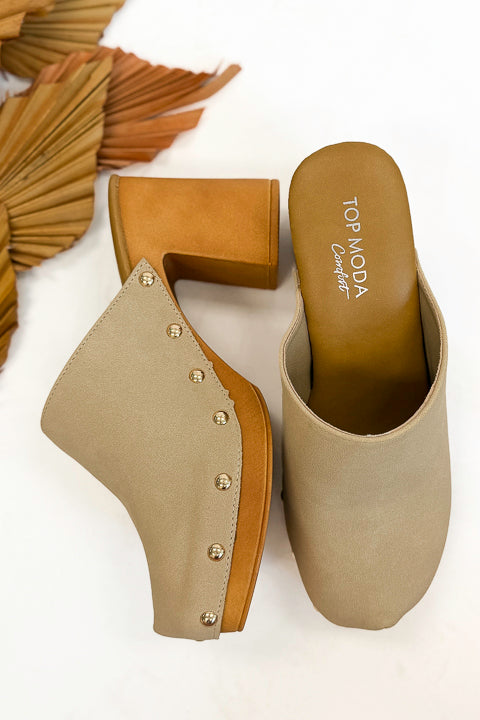 Jungle- Beige Studded Clogs against studio background