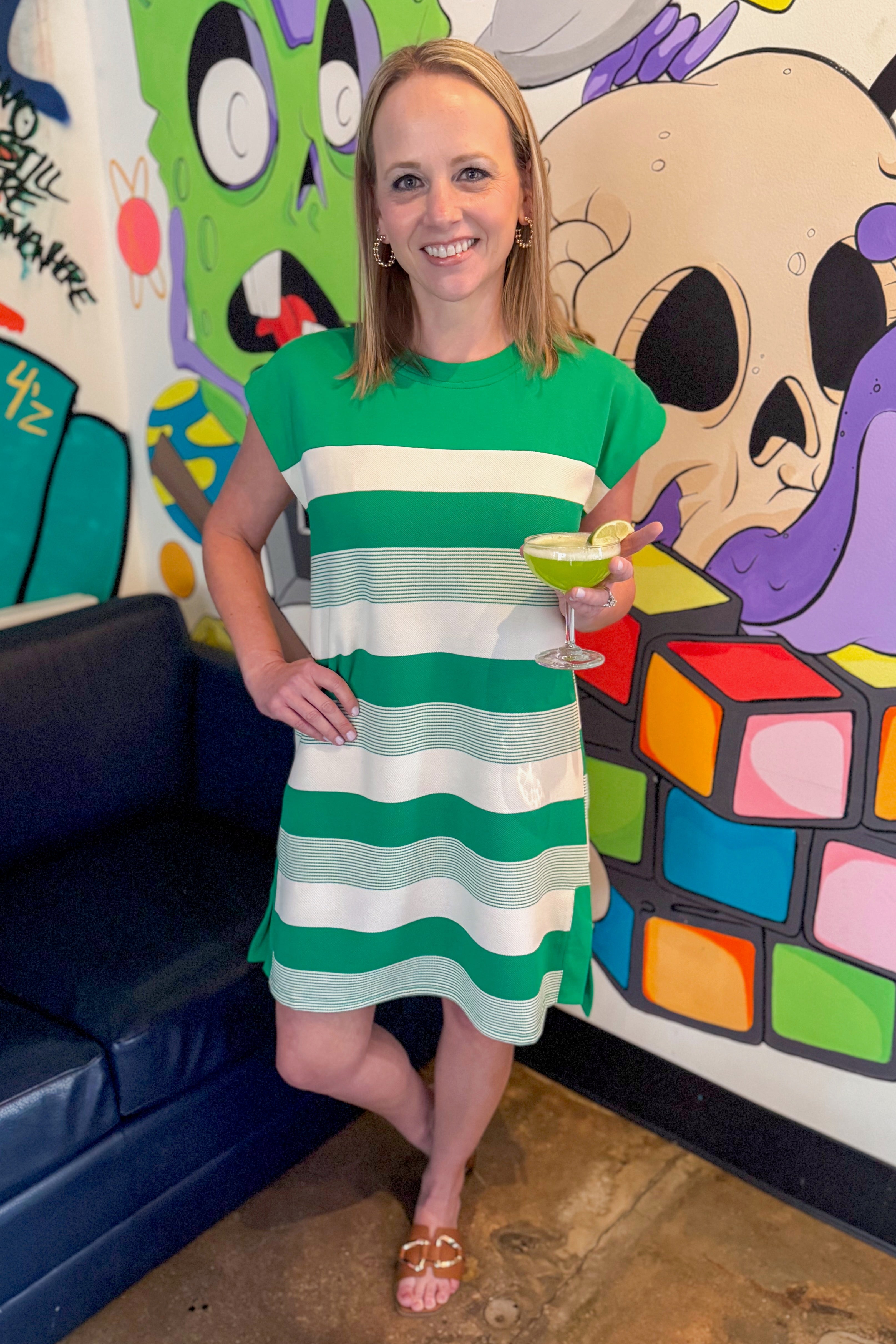 Front view of woman wearing Green Mixed Stripe Mini Dress at a restaurant.