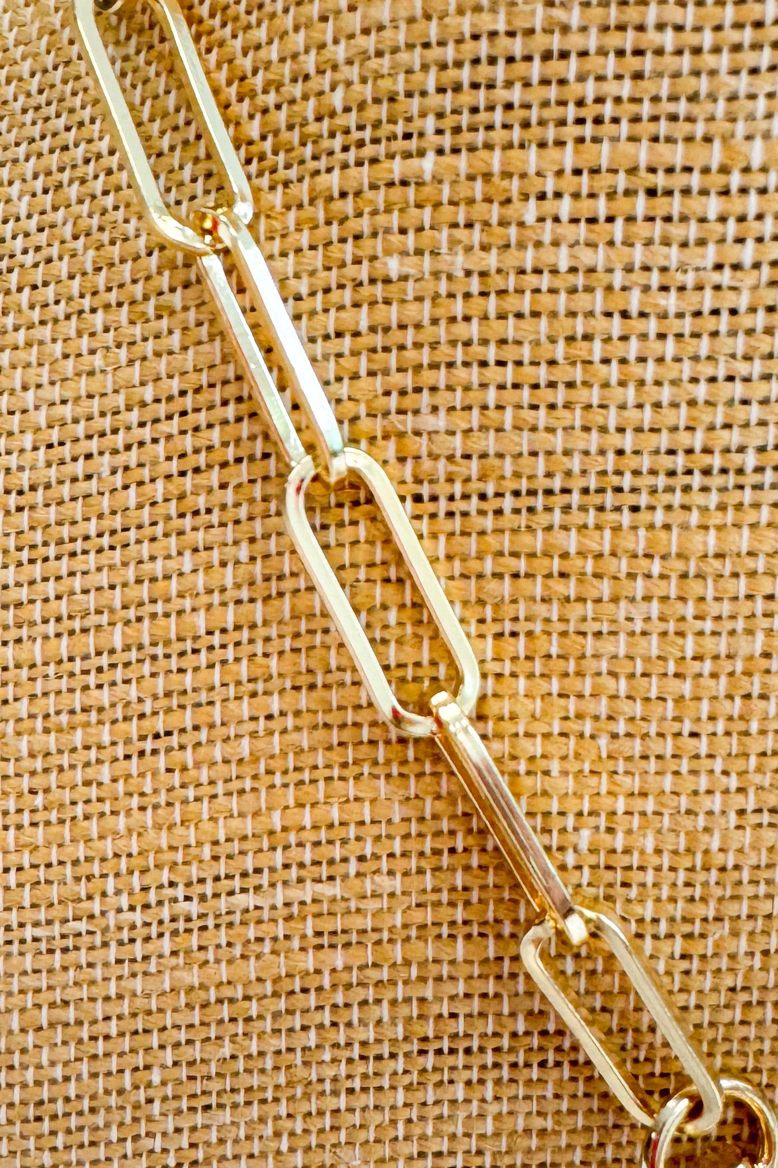 Gold chain on a textured brown fabric background