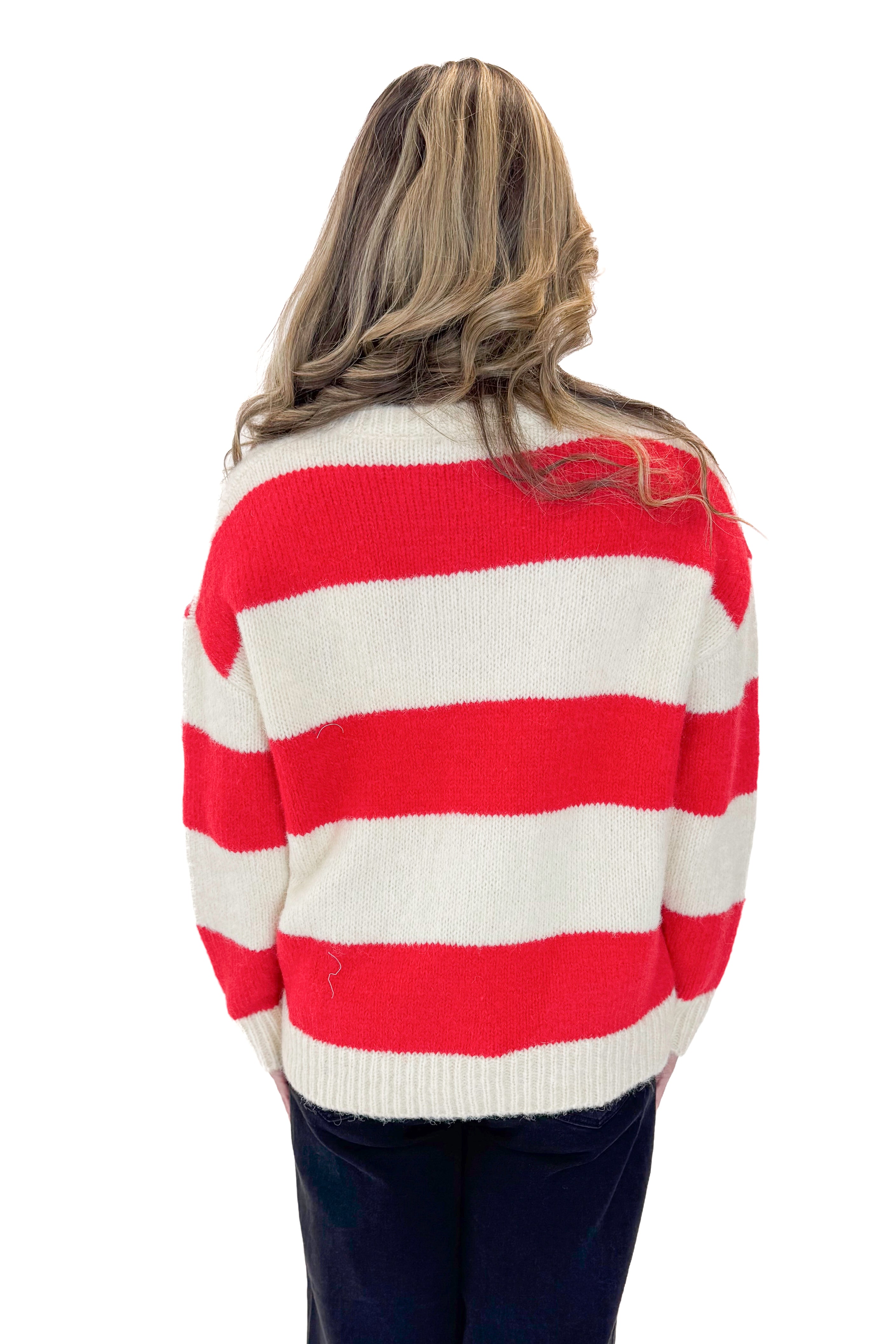 Back view of woman wearing Ivory & Red Striped Sweater with jeans against white studio background.