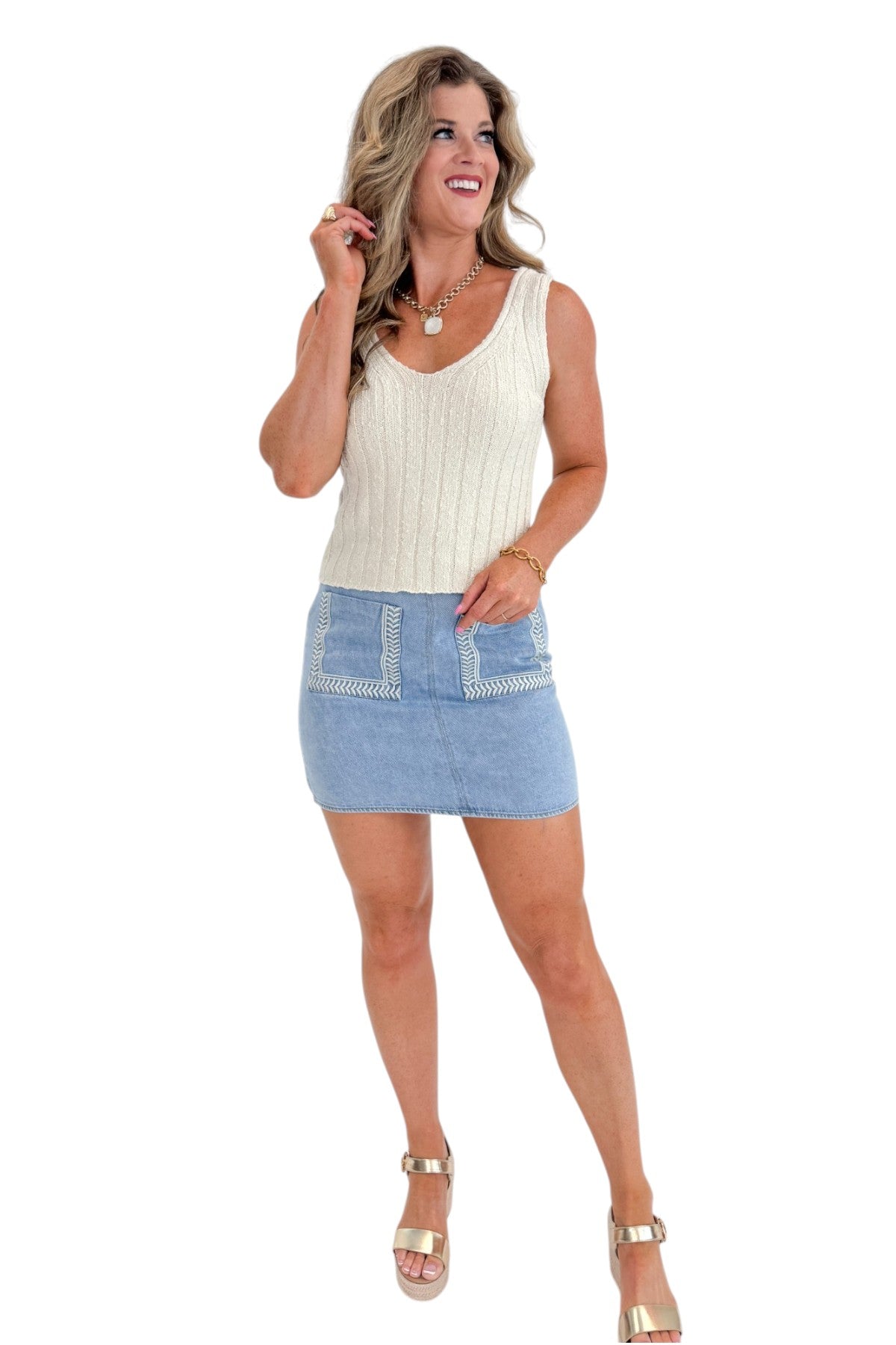 Front view of woman wearing Swagger Boutiqueβs Light Wash Embroidered Pocket Skirt with sweater against white studio background.